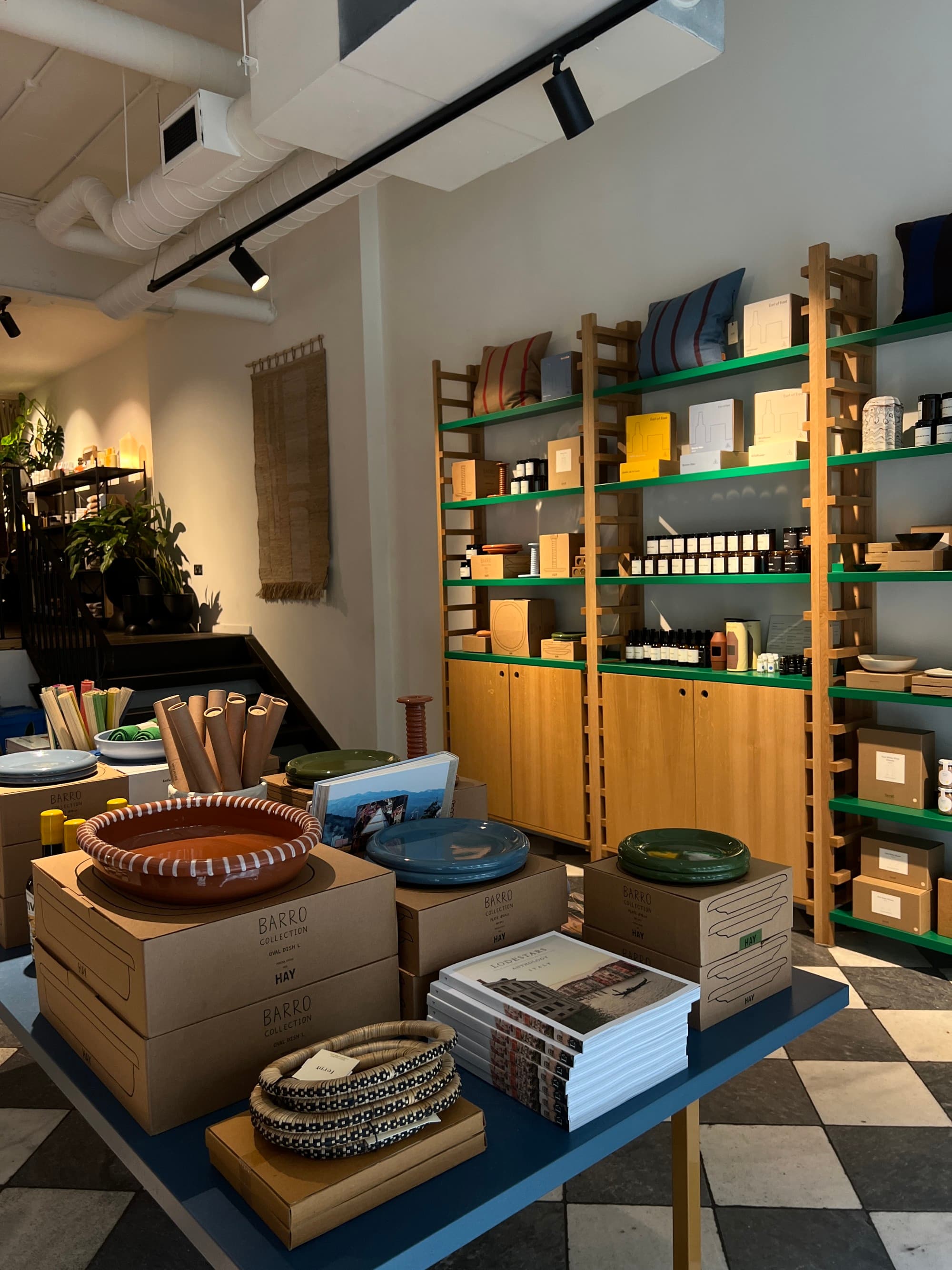 An indoor space with wooden shelves, cardboard boxes, and a white sofa, suggests a storage or display area.