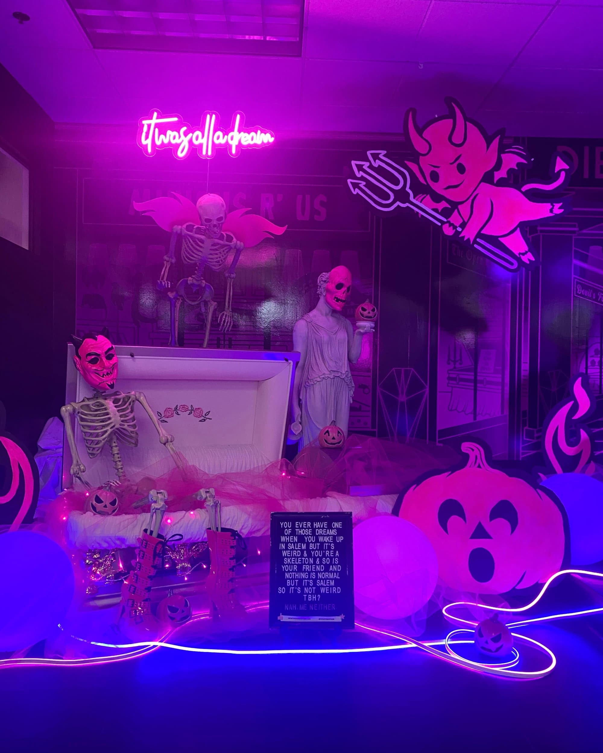 This image shows a room decorated with neon lights, skeletons, and pumpkins