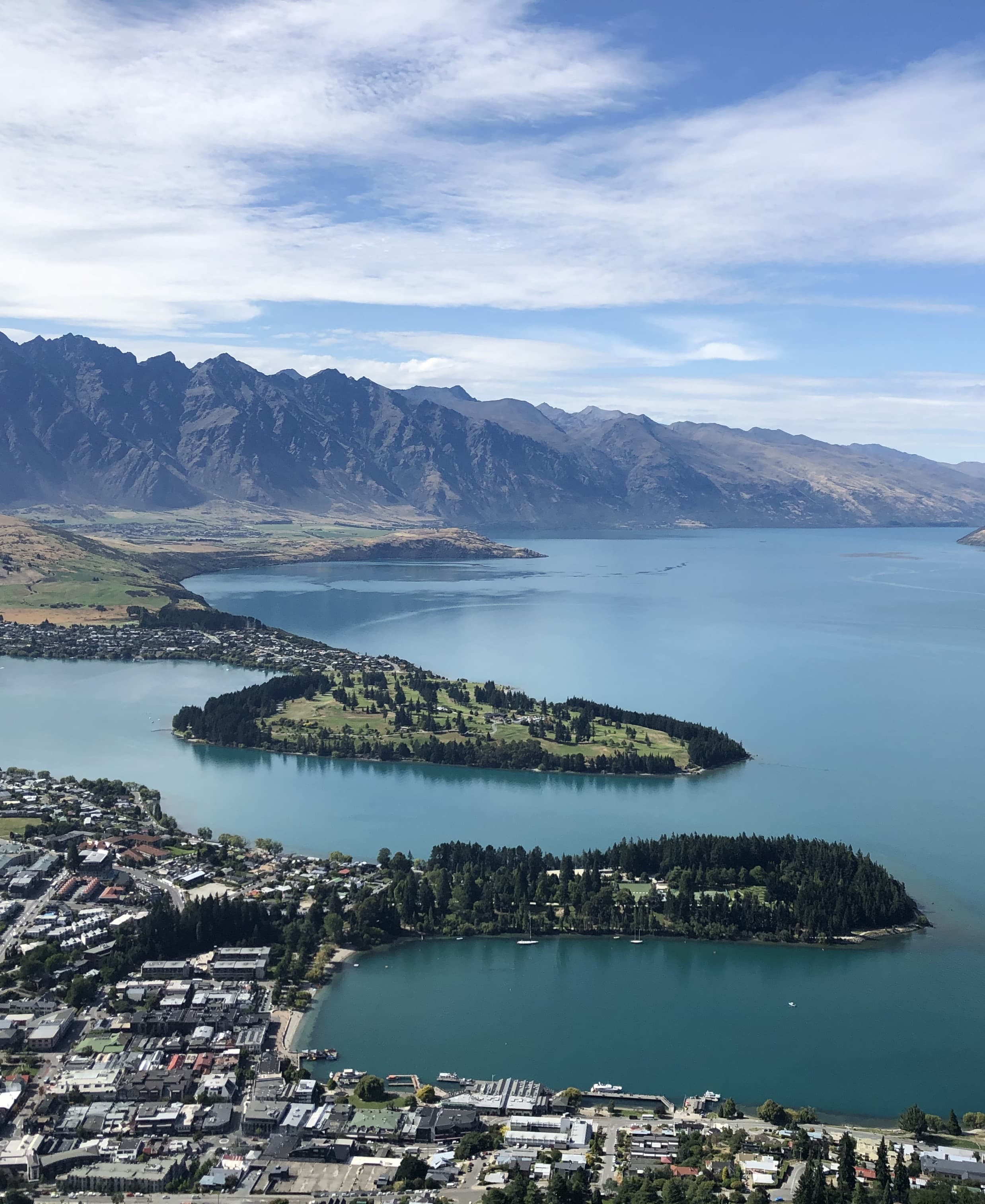 An aerial view of Queentown with bodies of water, islands and city landscape.