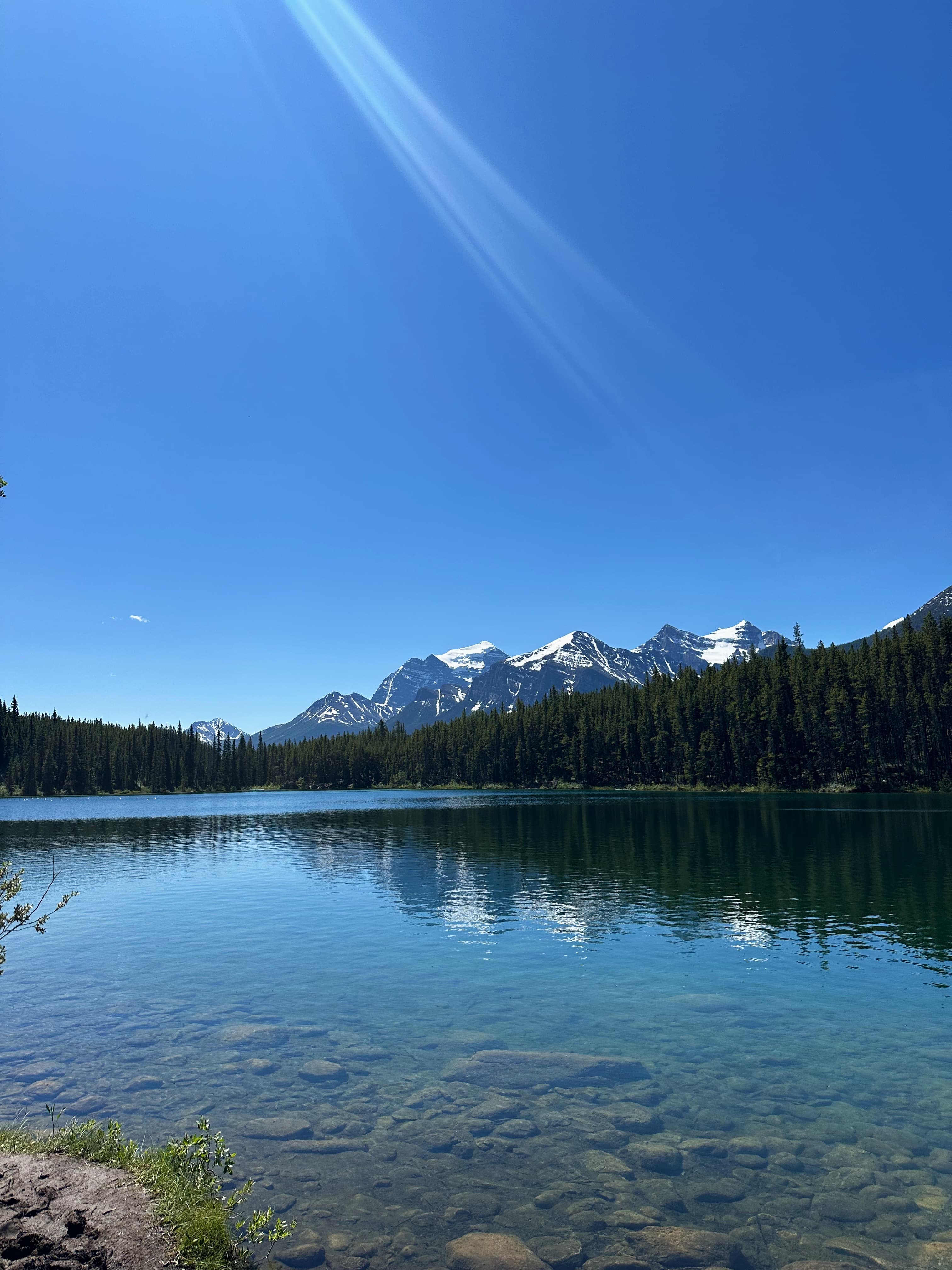 View of the snow-capped mountains beyond a lake.