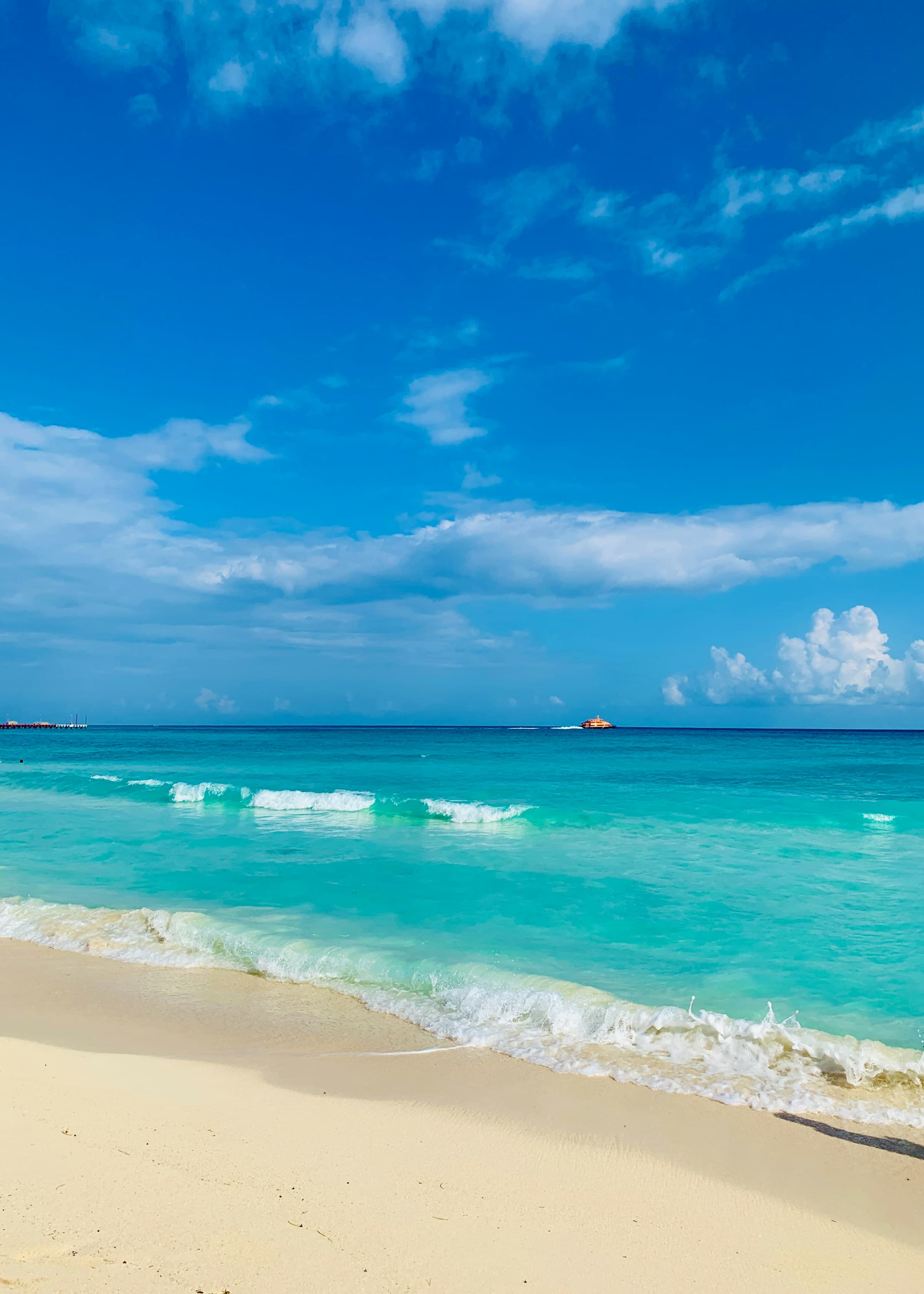 White sandy beach and blue waters at a beach in Tulum.