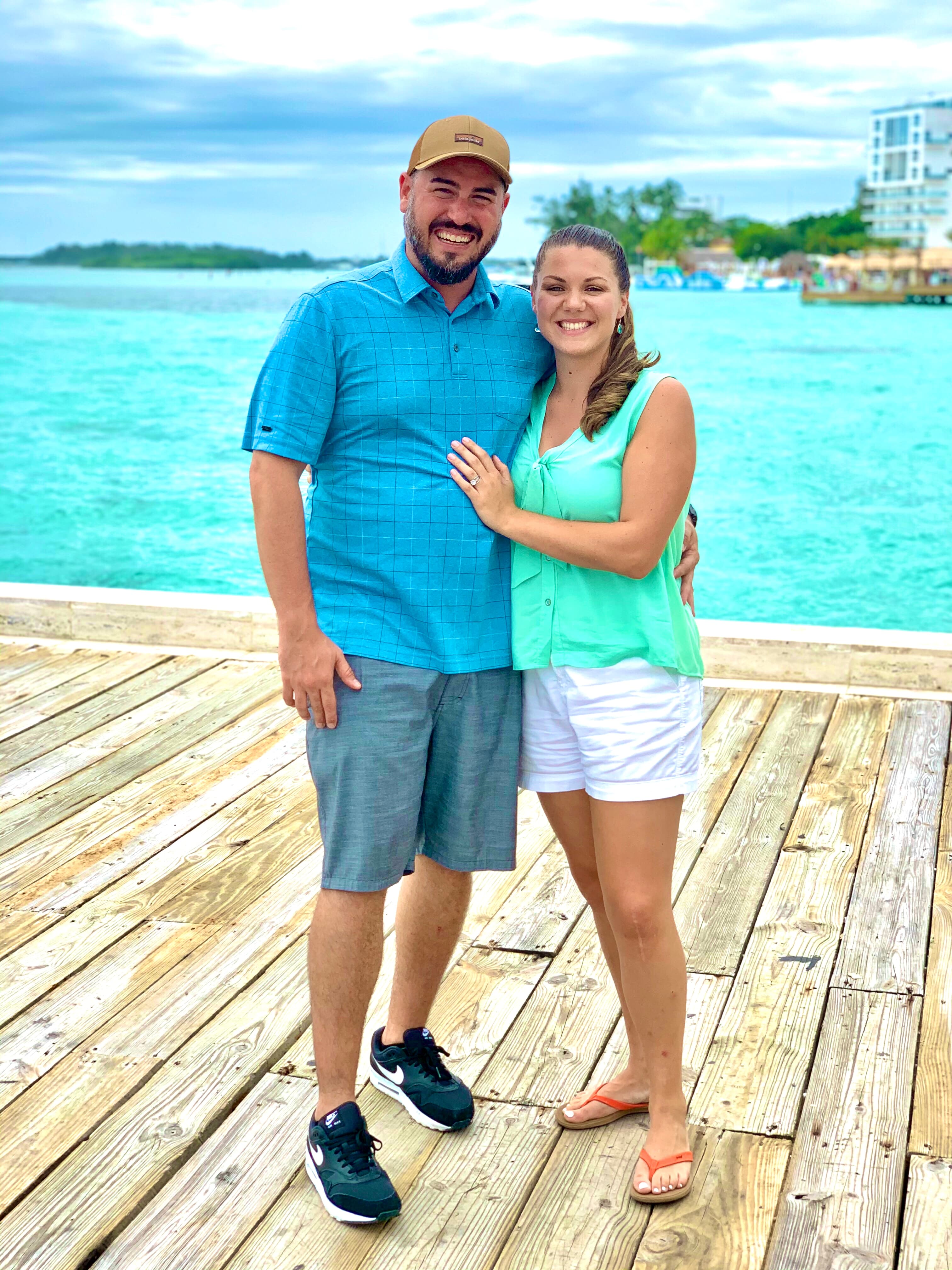 The advisor and her husband standing on the dock at Boca Marina with a gorgeous view of the water.