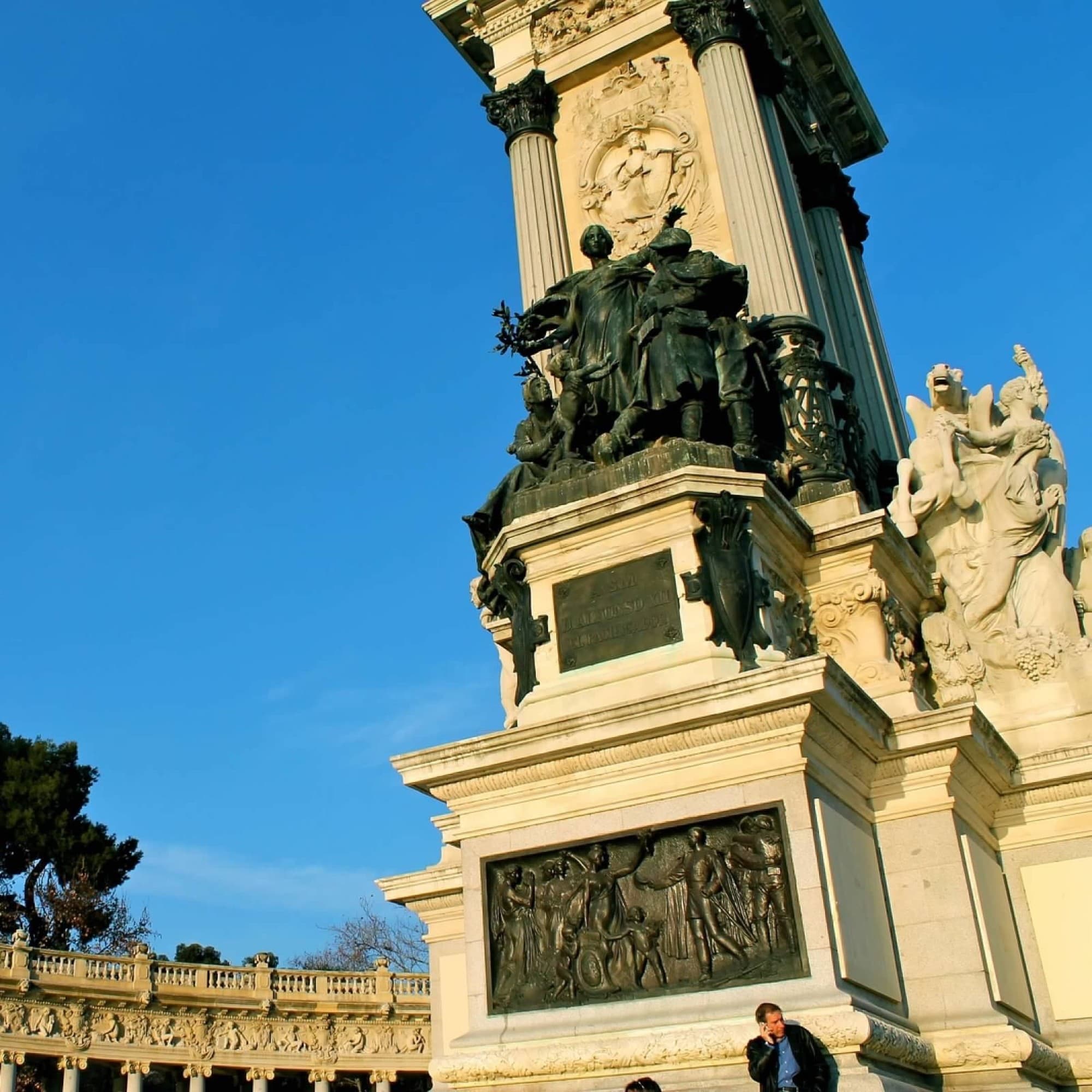 A detailed monument with sculptures and bas-reliefs under a clear blue sky.