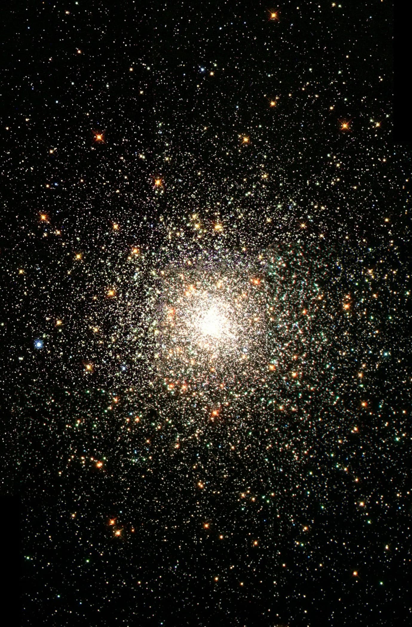 A dense cluster of stars with a bright concentration at the center, possibly depicting a globular cluster in space.