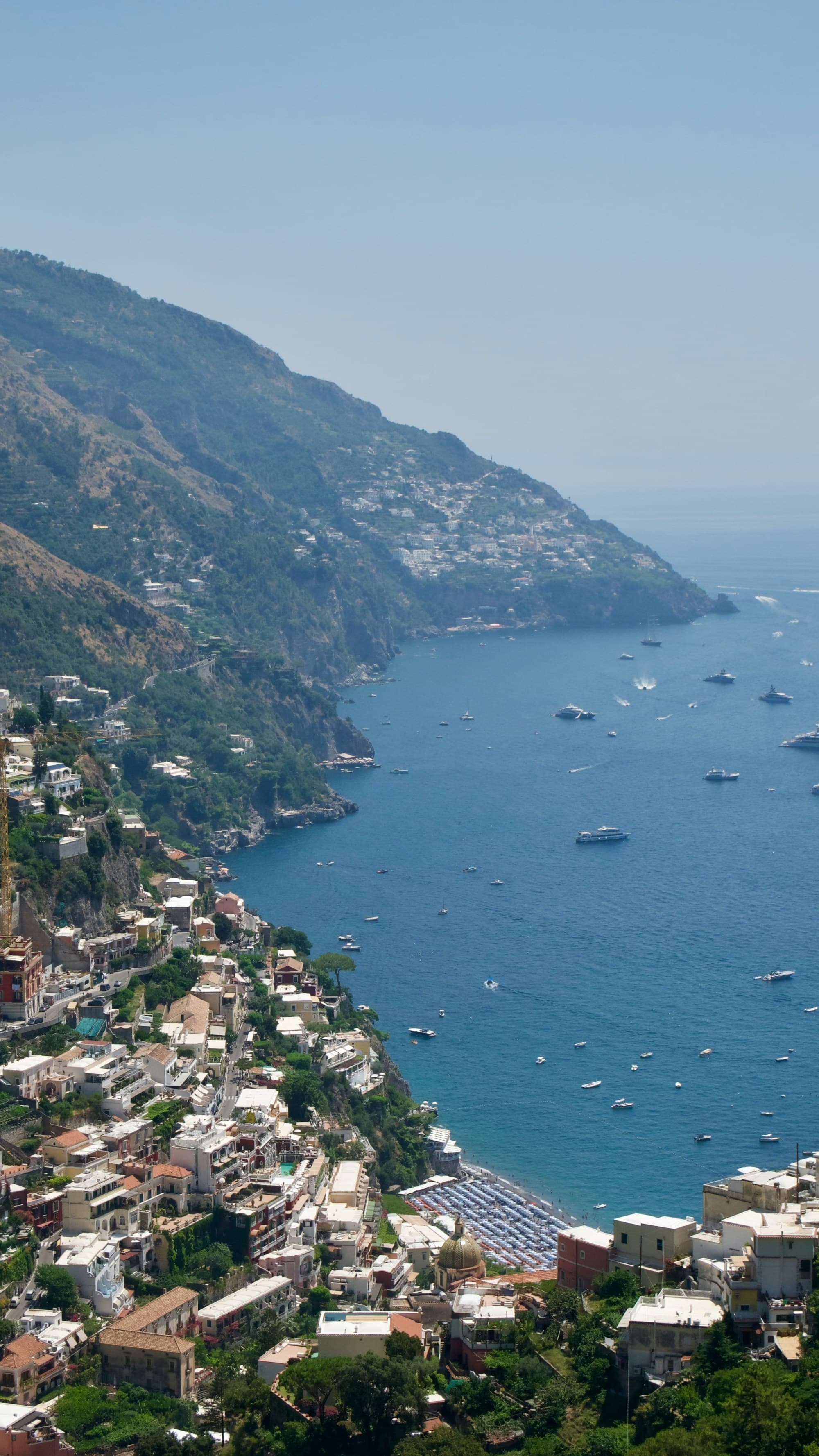 A view from high on a mountain looking down on the city and the ocean coastline.