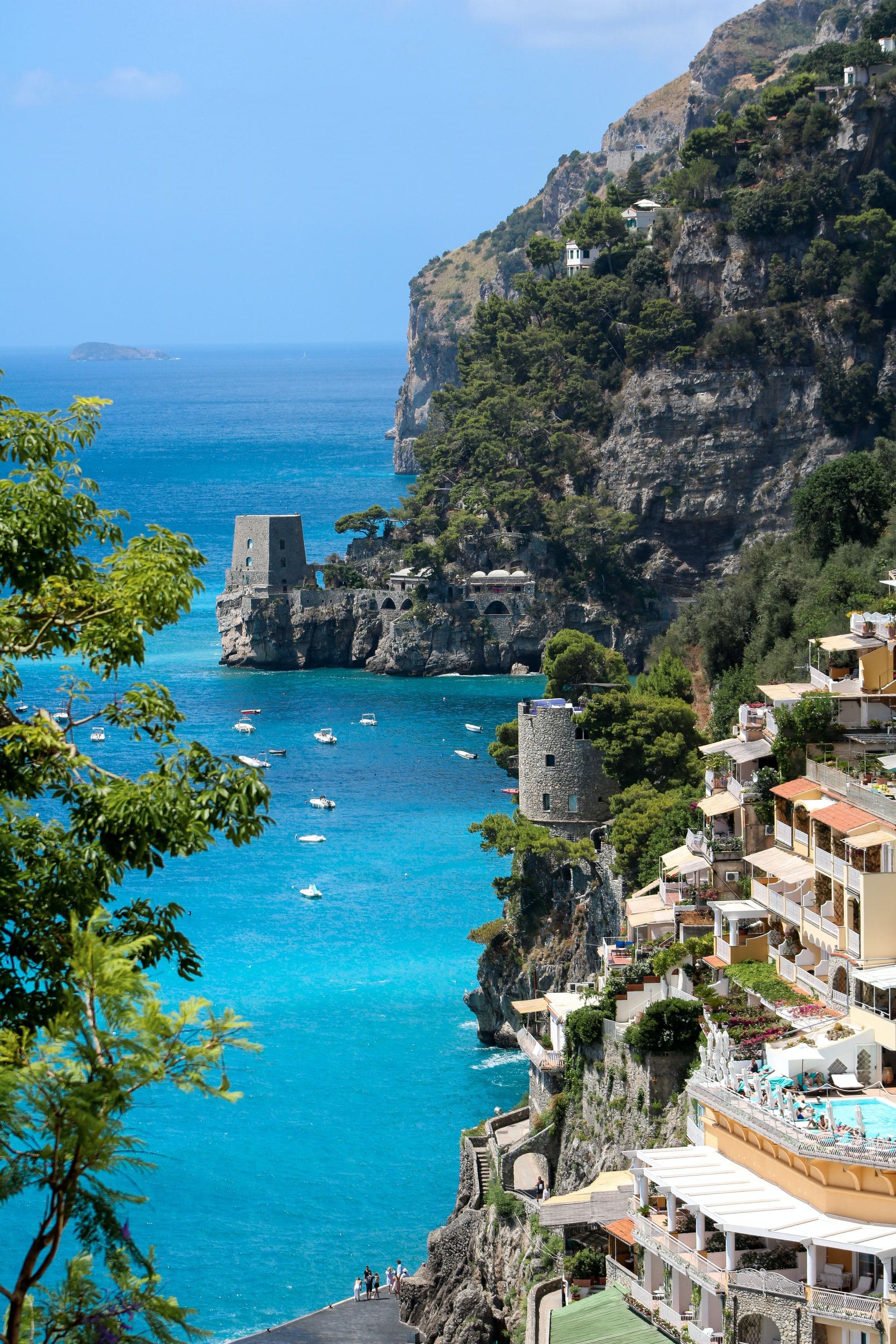 a town built into the cliff into clear blue ocean water