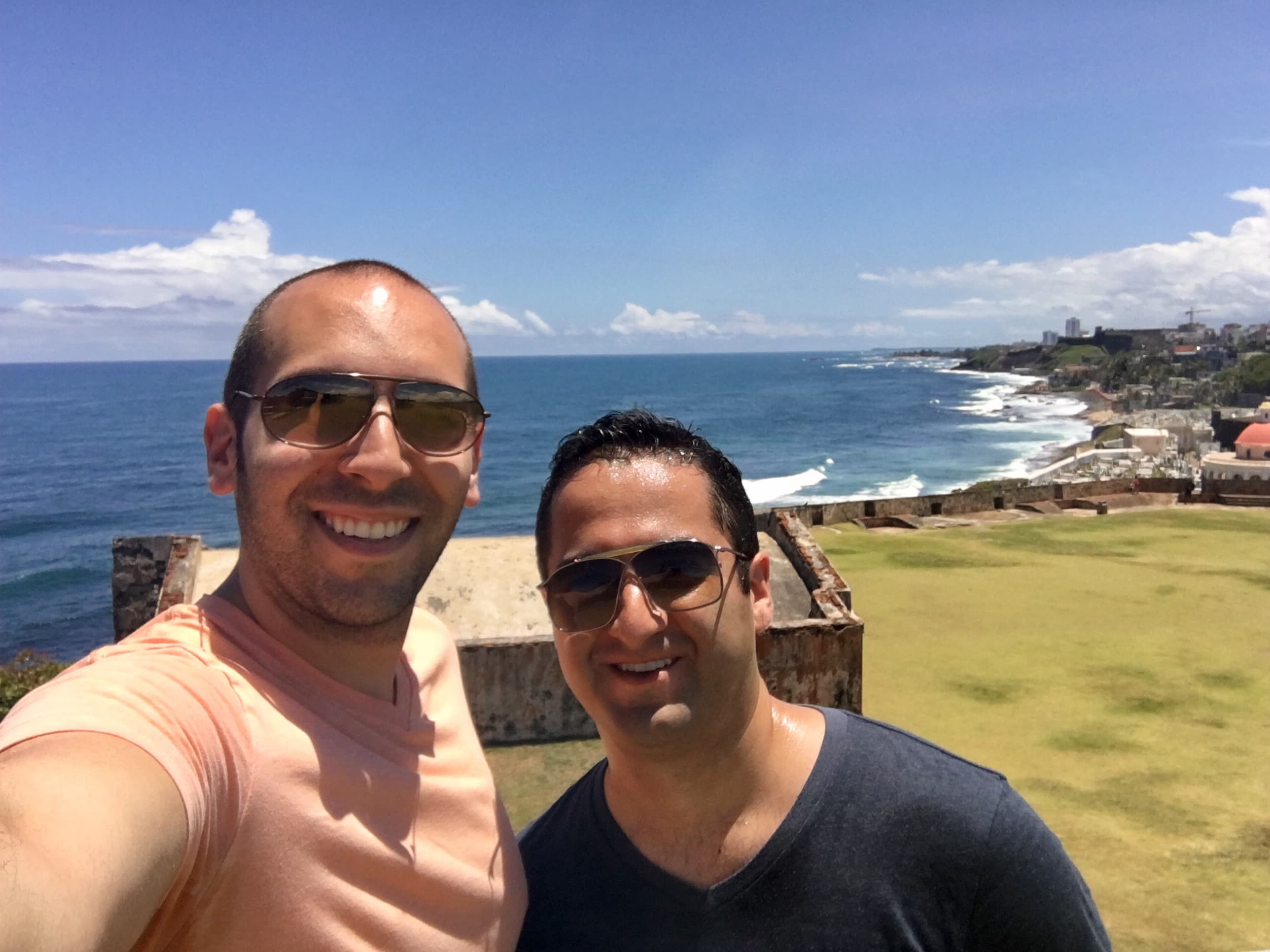 Two friends outdoors near the beach during the daytime.