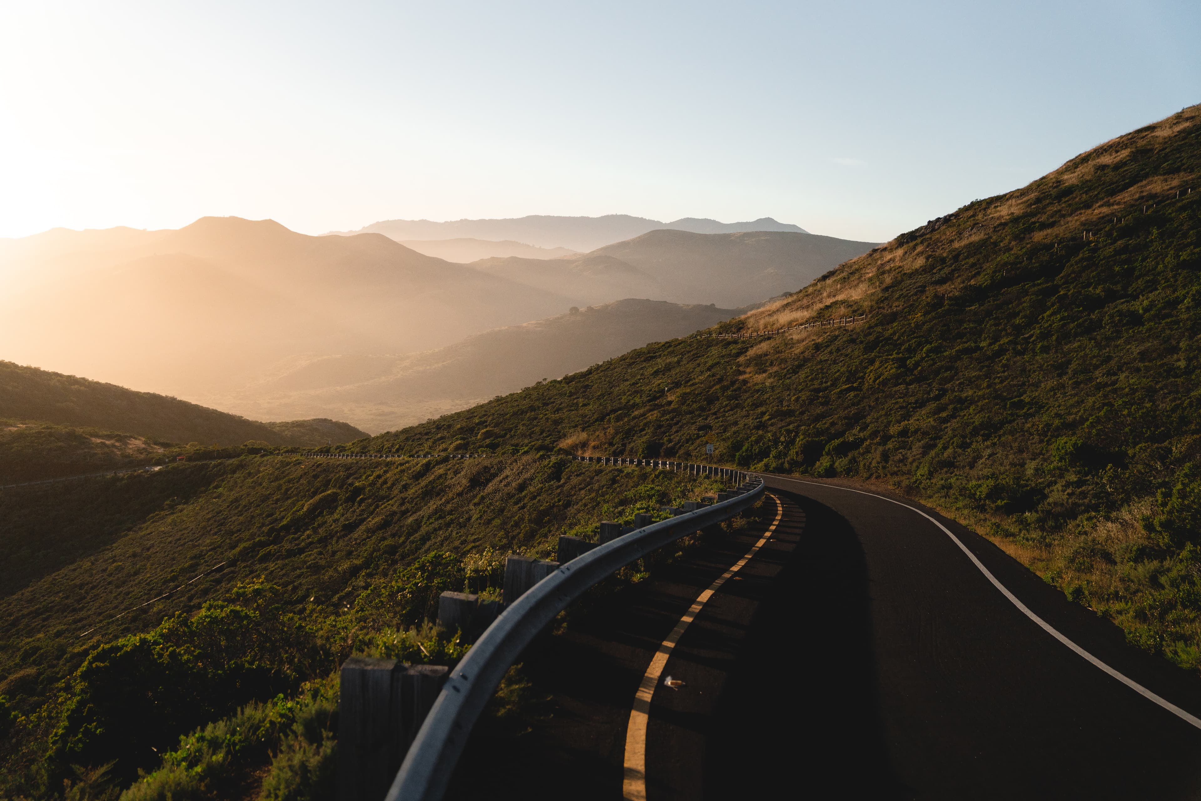 paved road through mountain region during sunset