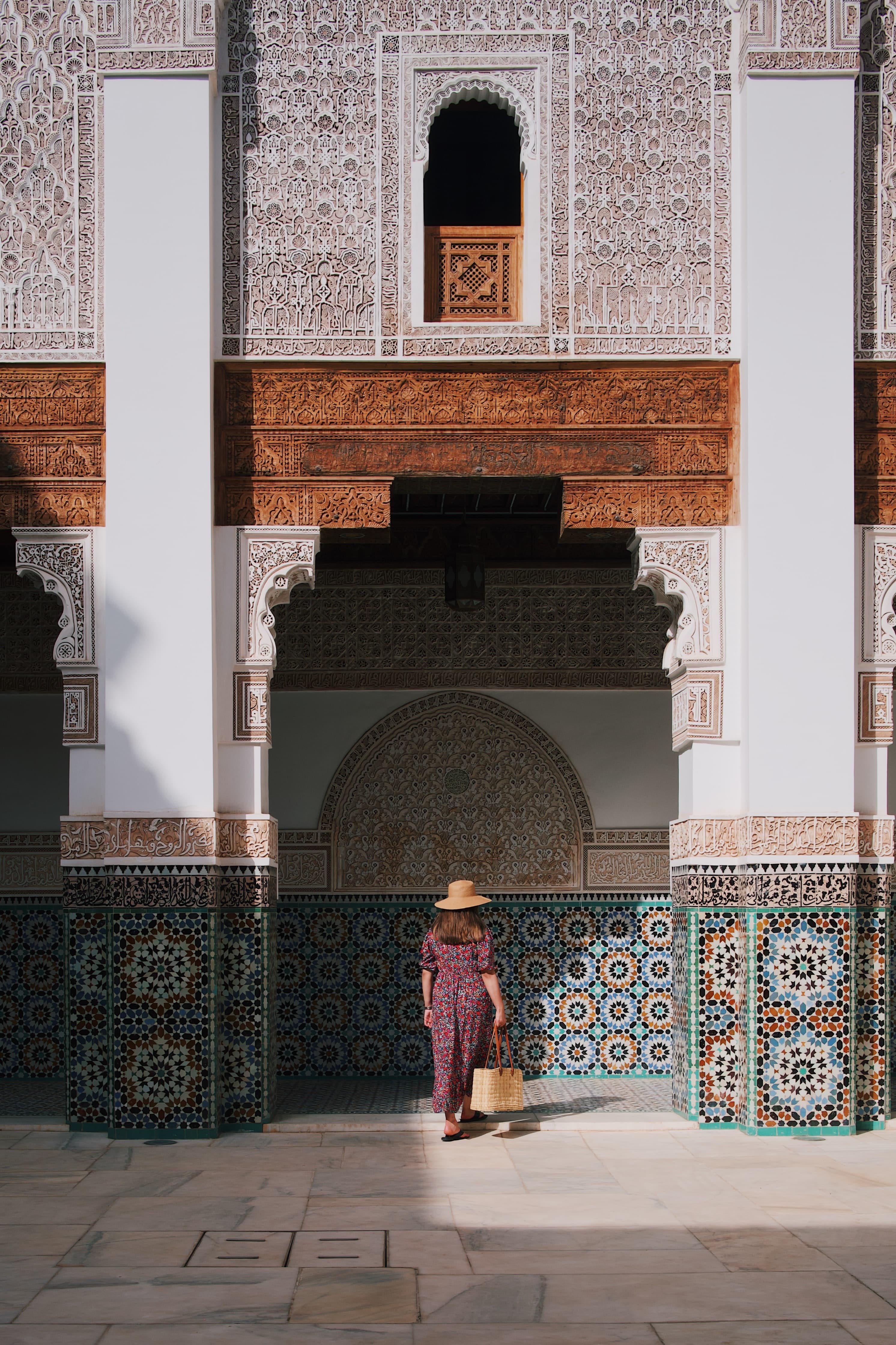 woman standing next to building with colorful tile during daytime