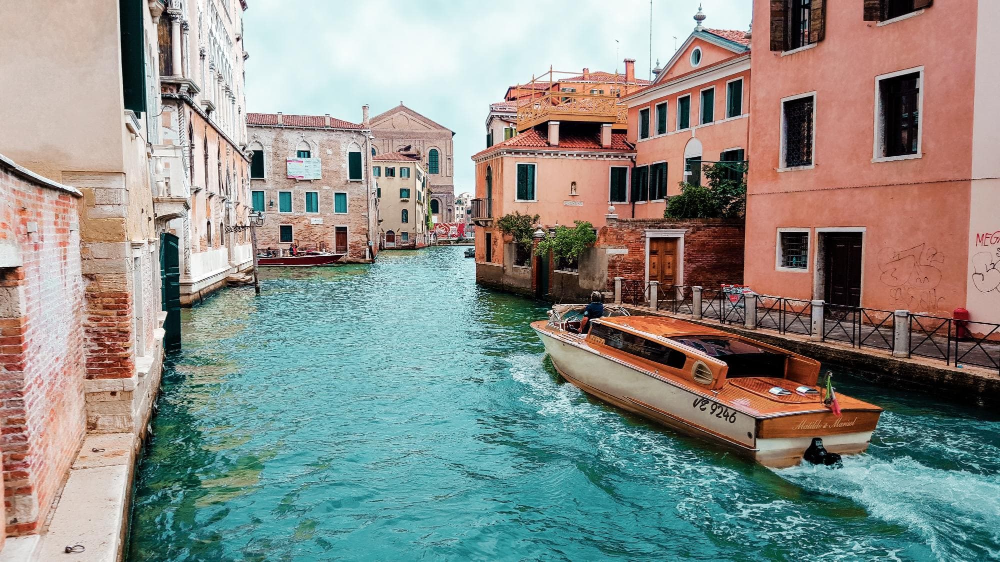 Boat on lake in the city flowing between buildings.