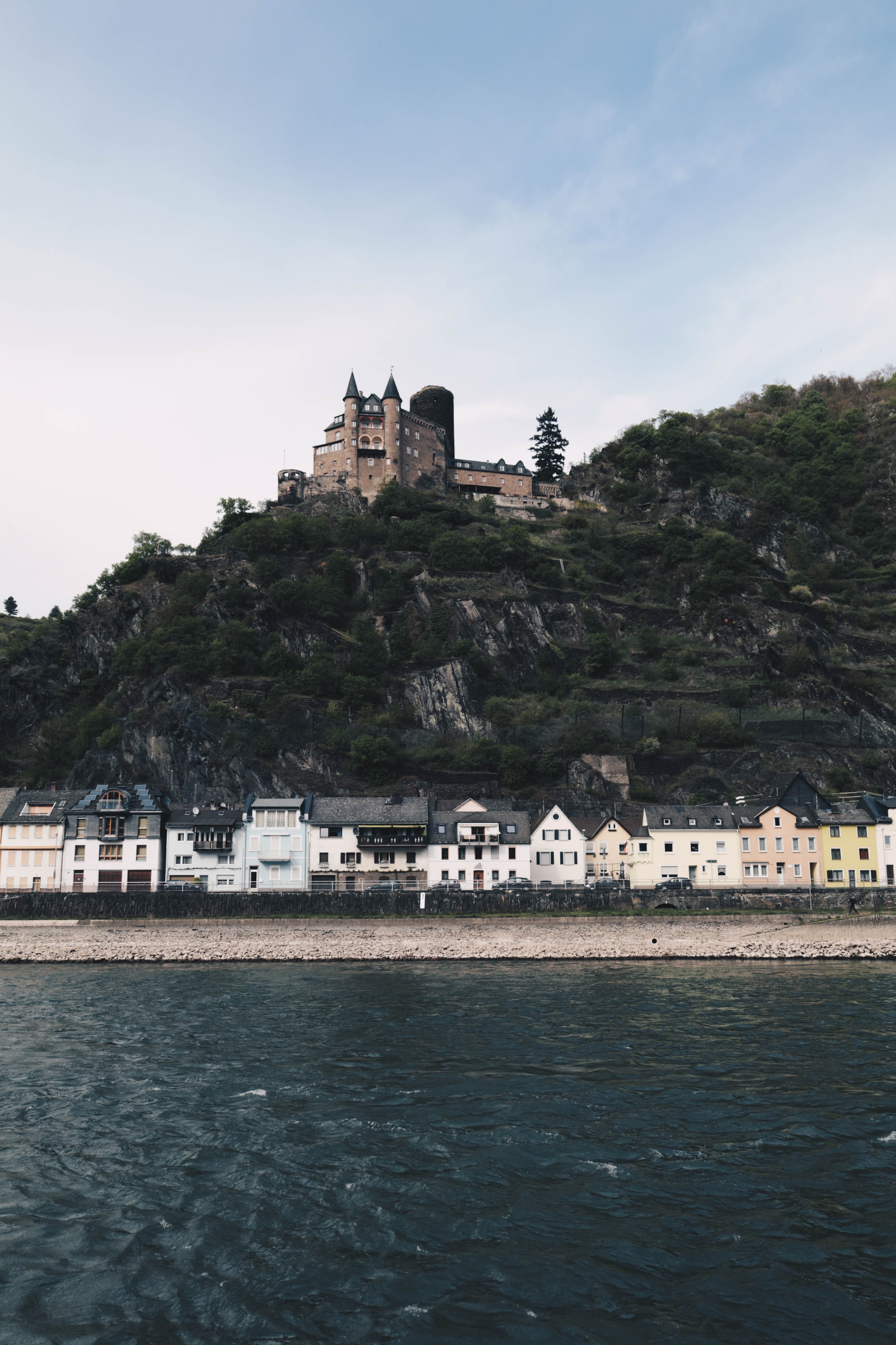 A river posted with houses and a mountain.