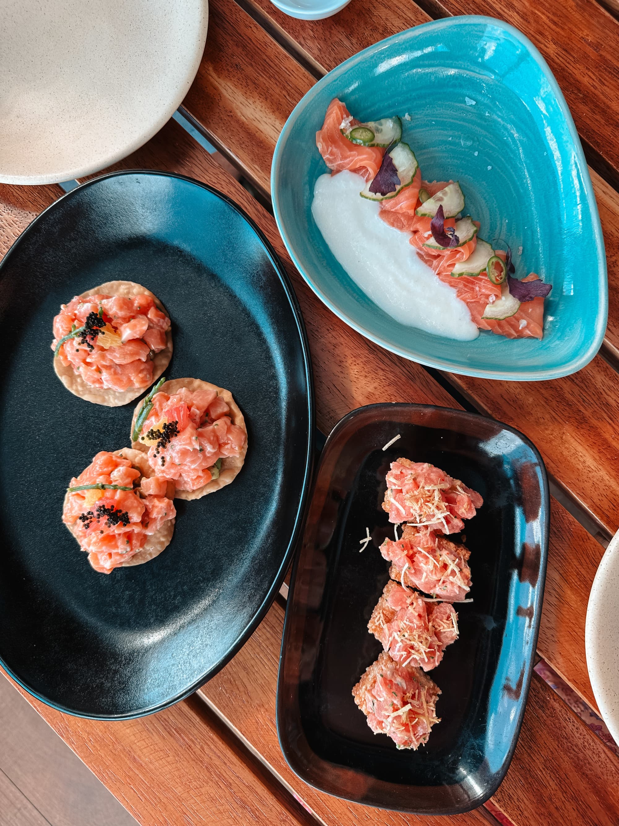 Three plates of seafood dishes.