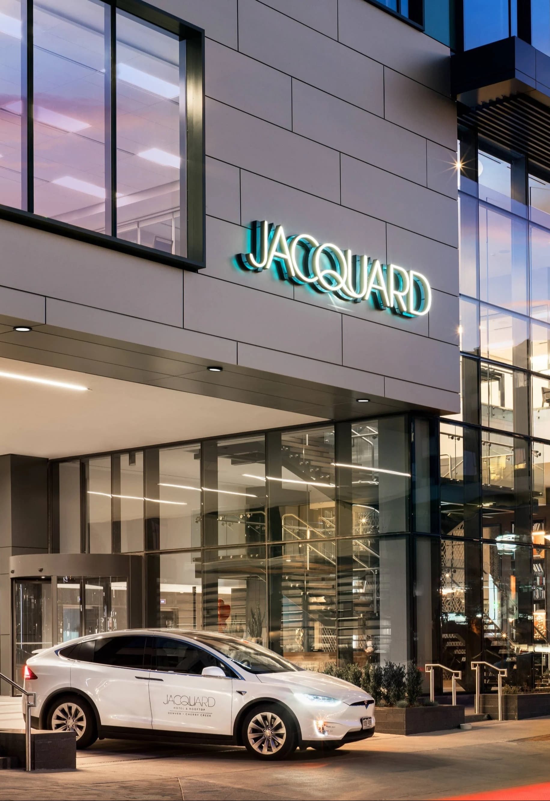 Facade of The Jacquard, Autograph Collection hotel with an SUV emerging from underground parking.