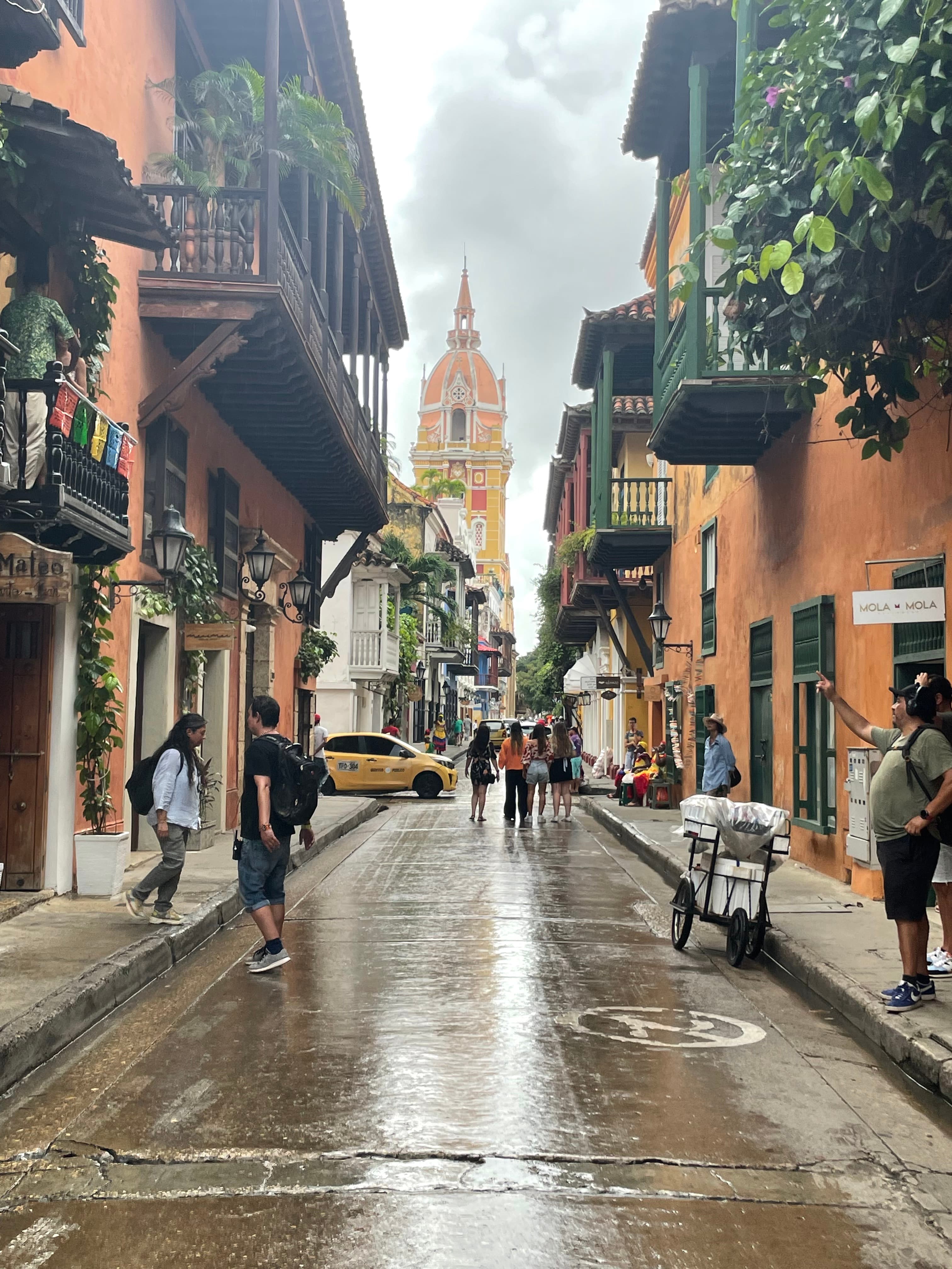 Streets of Cartagena with colorful buildings and pedestrians.