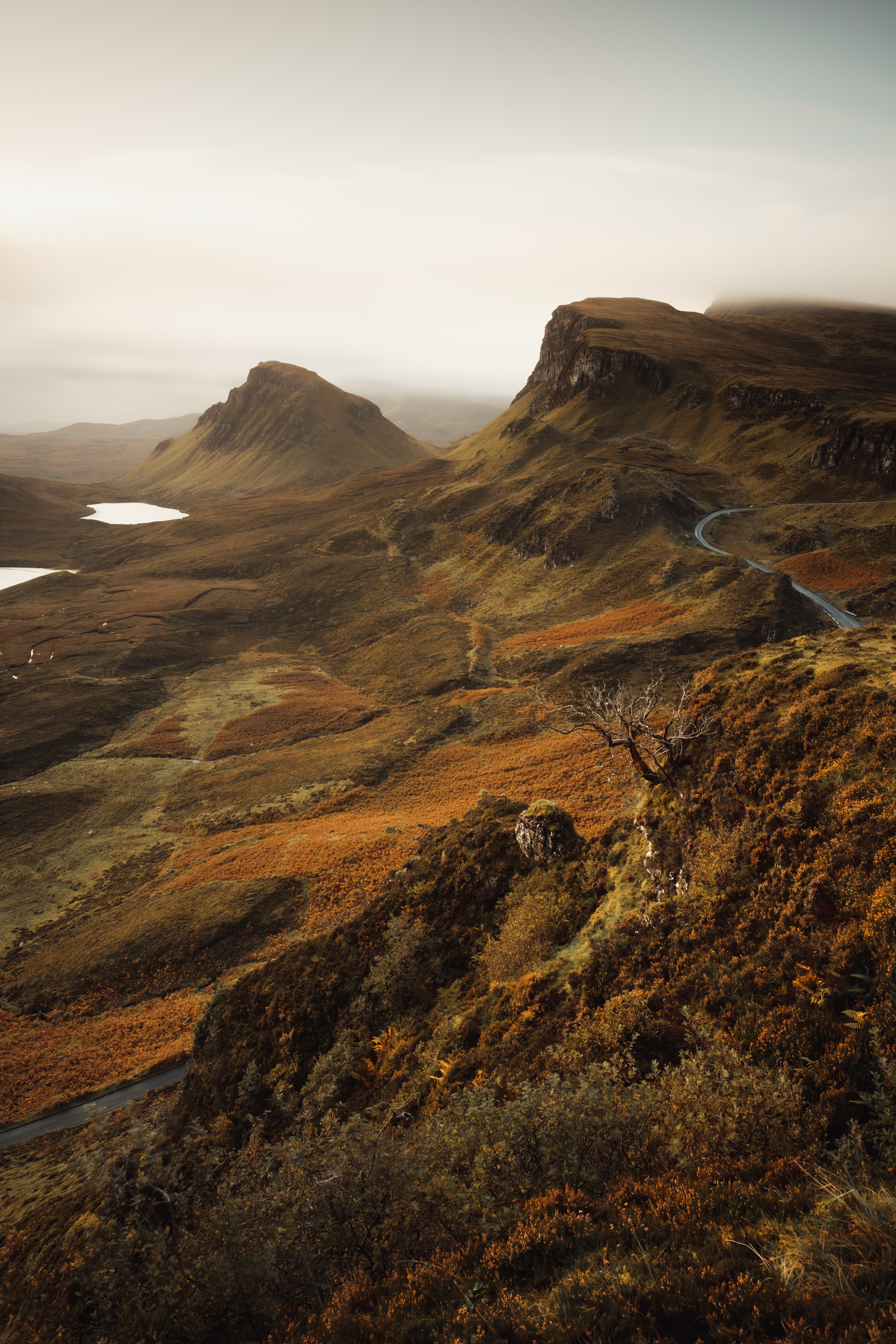 A Scottish countryside featuring hills and cliffs in fog.