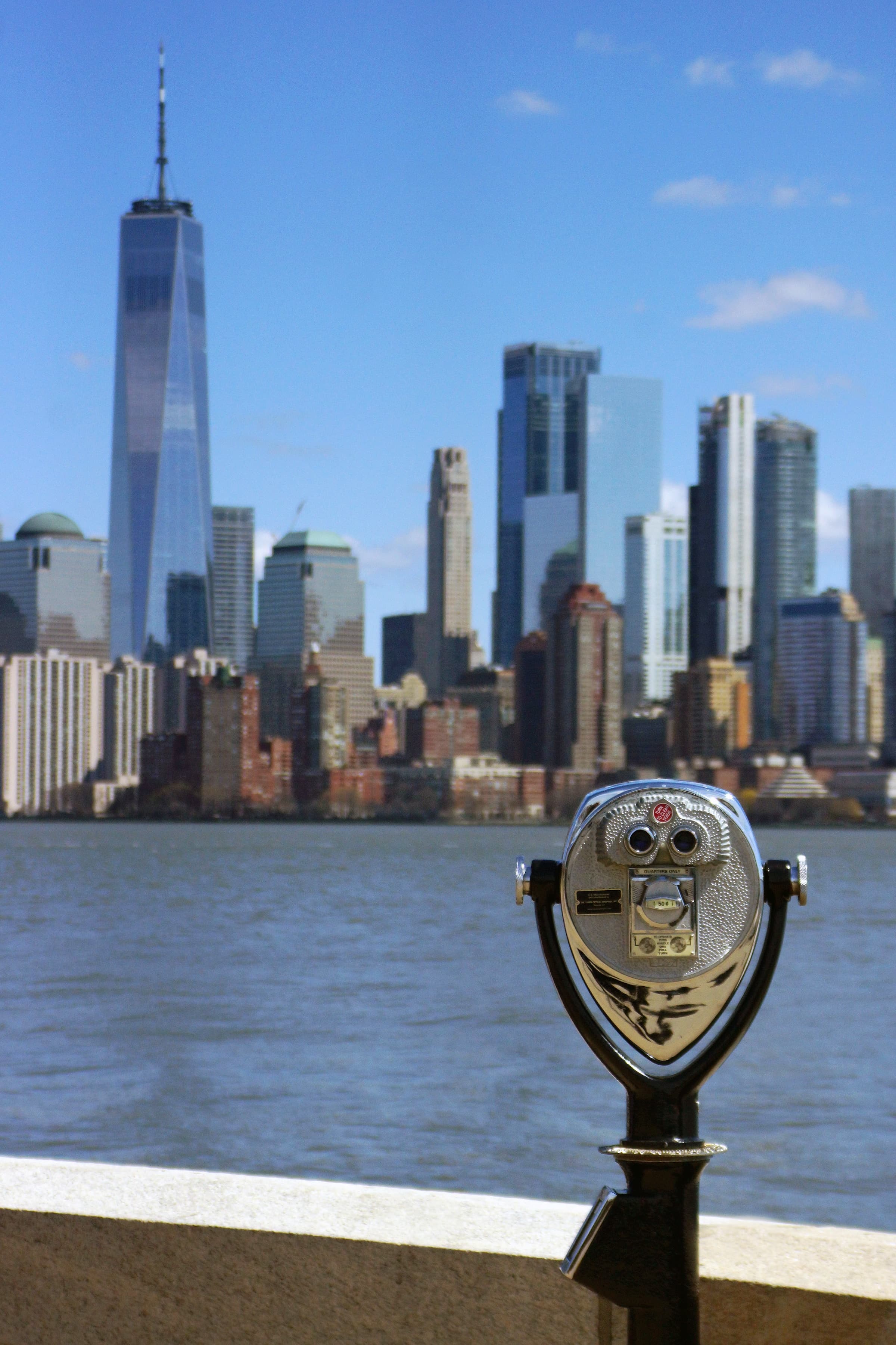 New York Manhattan from a distance with a coin-operated binocular machine at the forefront.