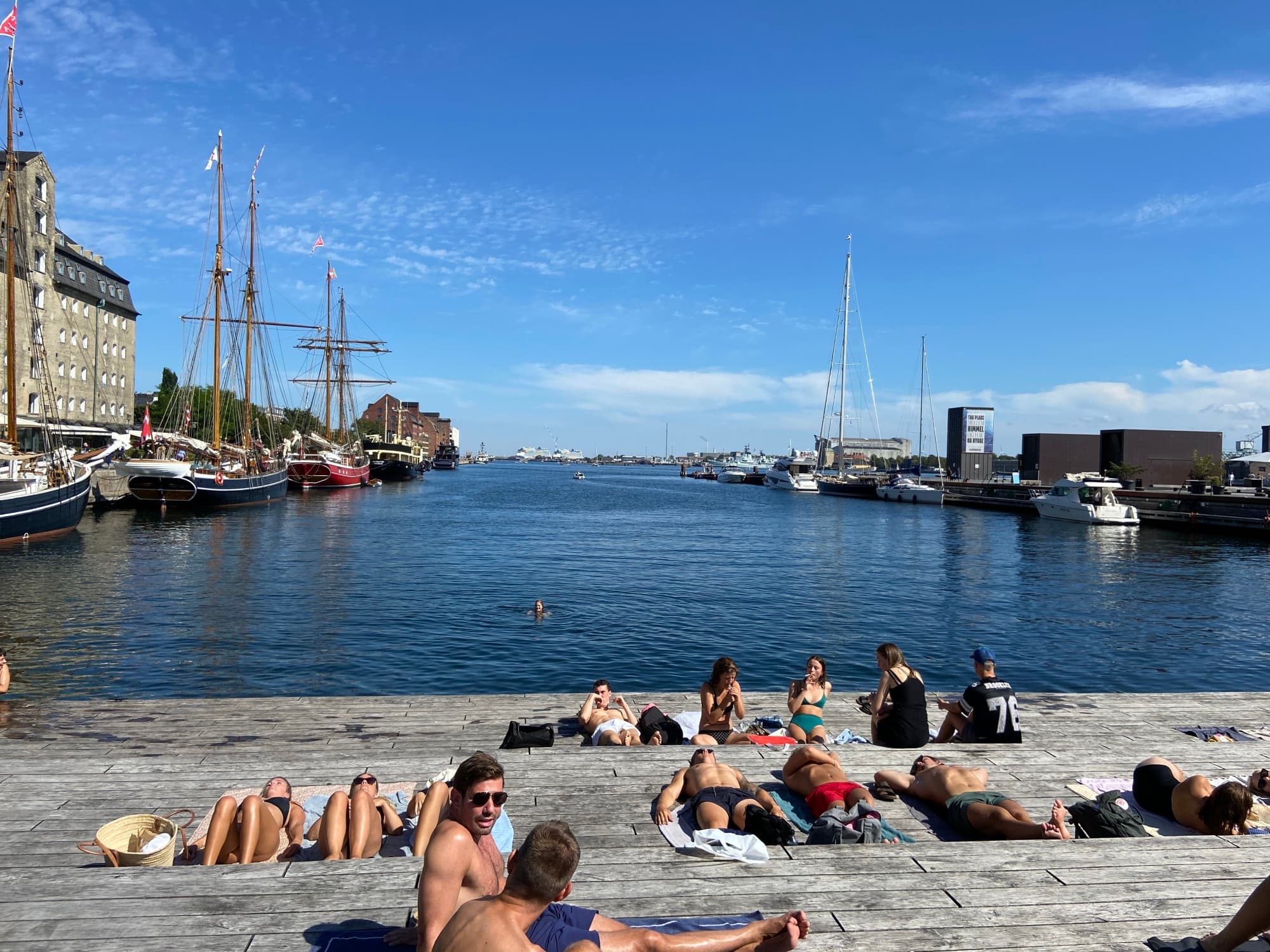 people sun tan on a dock