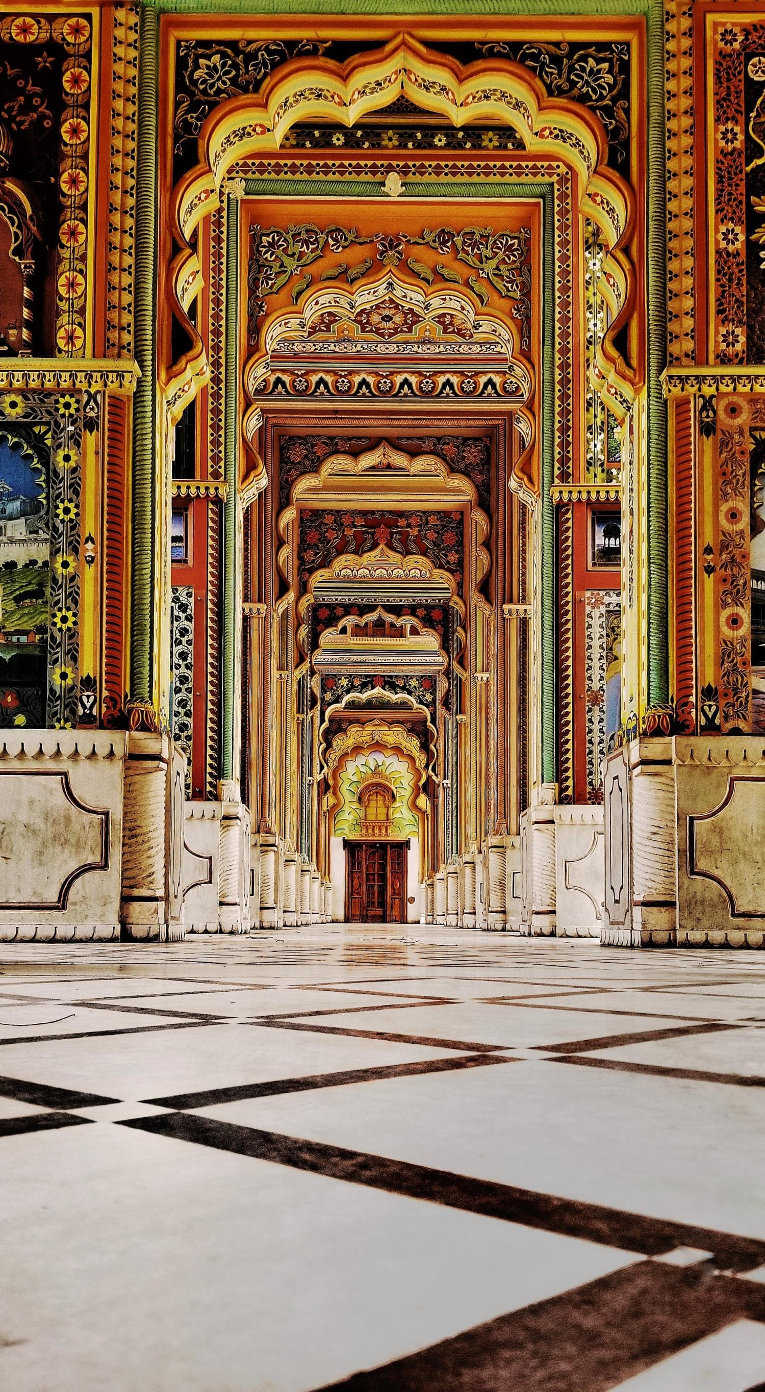 Vibrant and intricate pattern with reds, yellows, blues and green on arches of Patrika Gate in Jaipur.