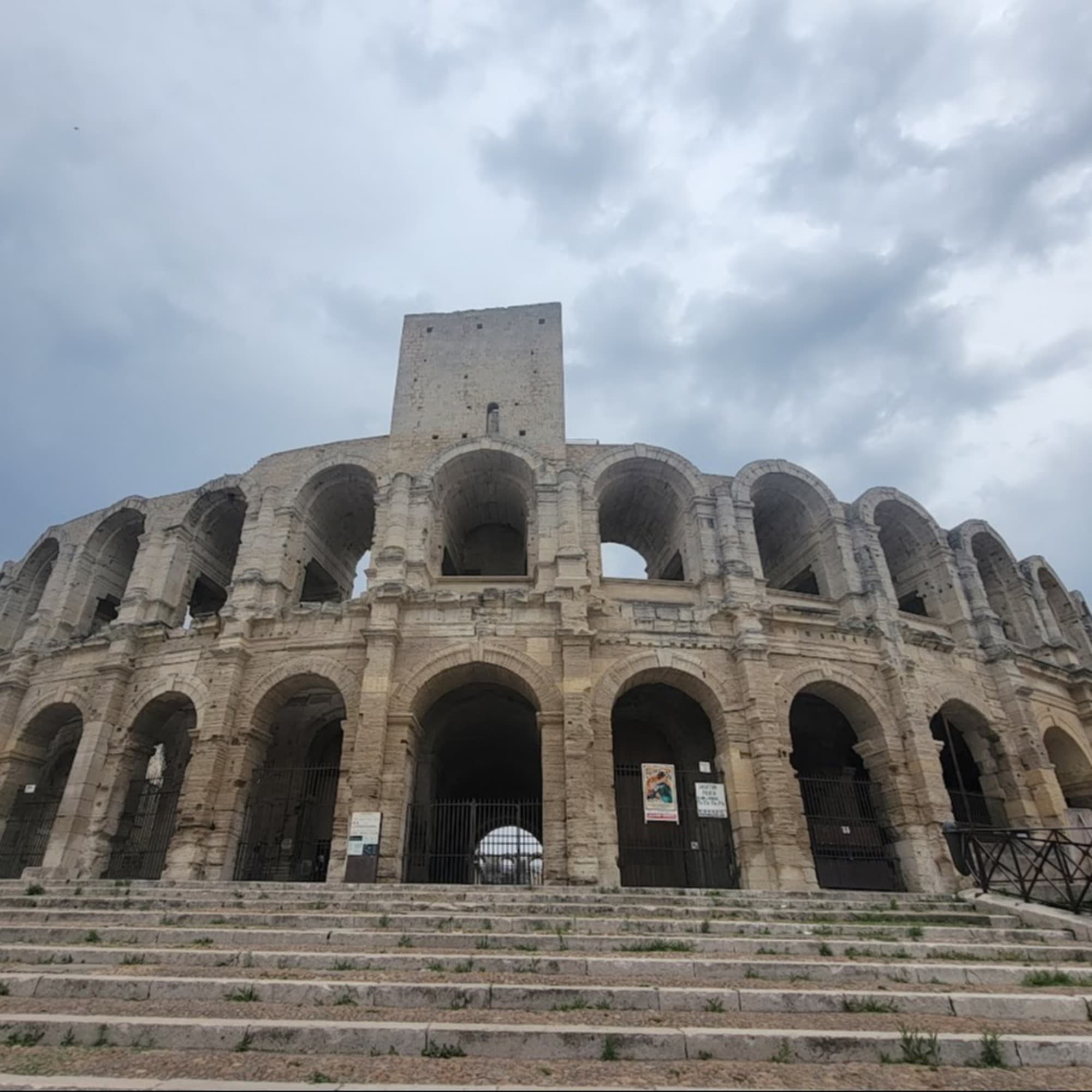 A picture of people standing near an ancient building during the daytime.