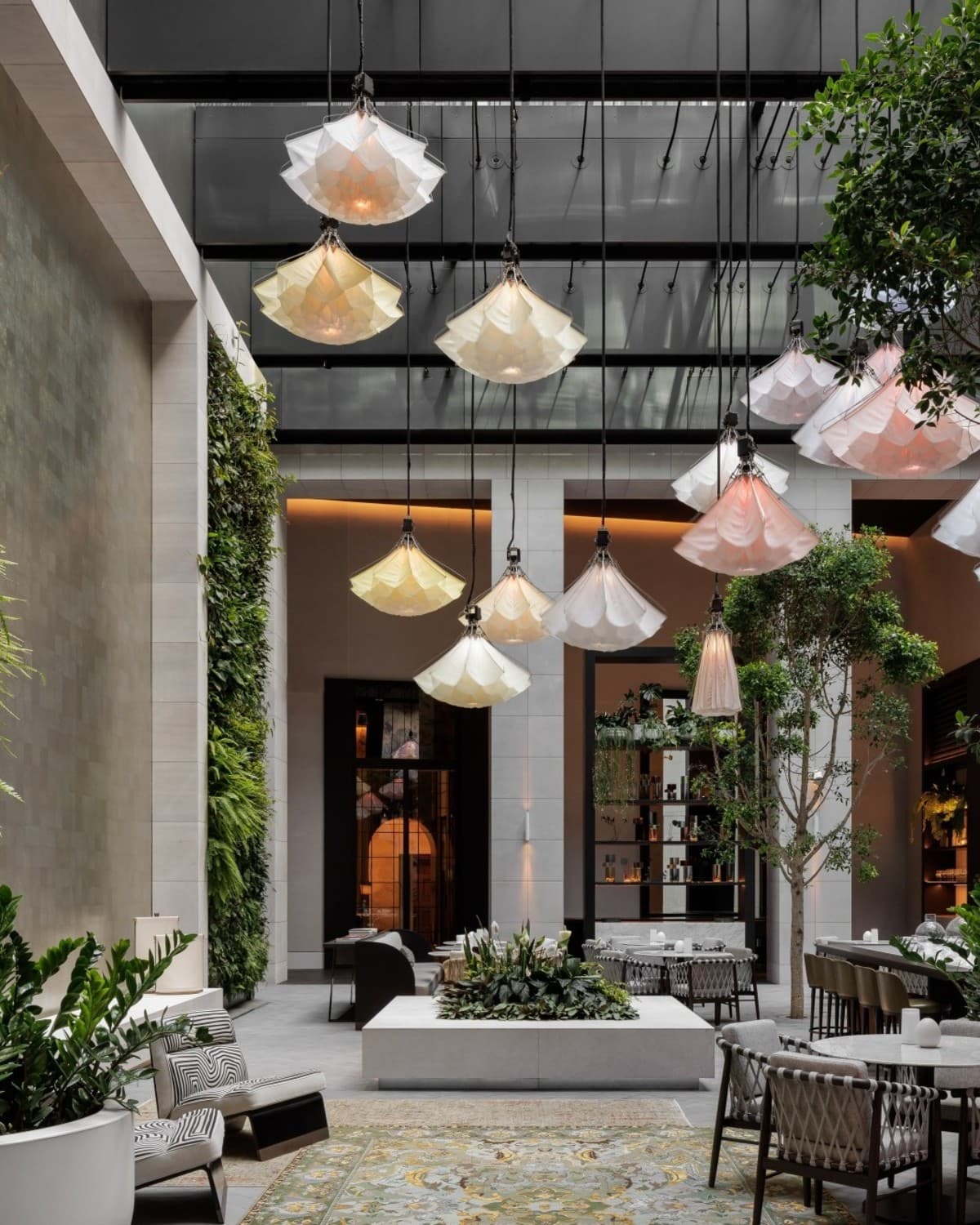 long white hanging lights in an airy lush courtyard