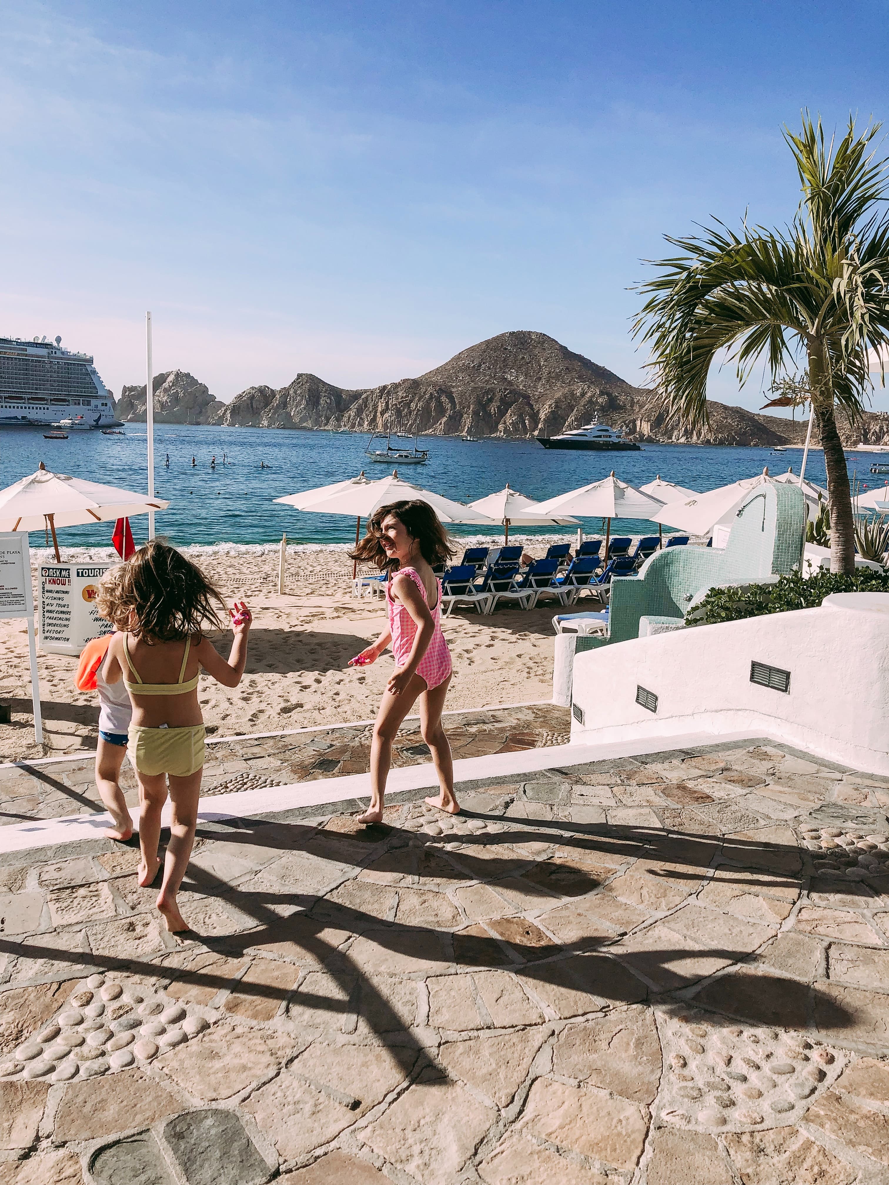 children standing on pool deck with mountain in background