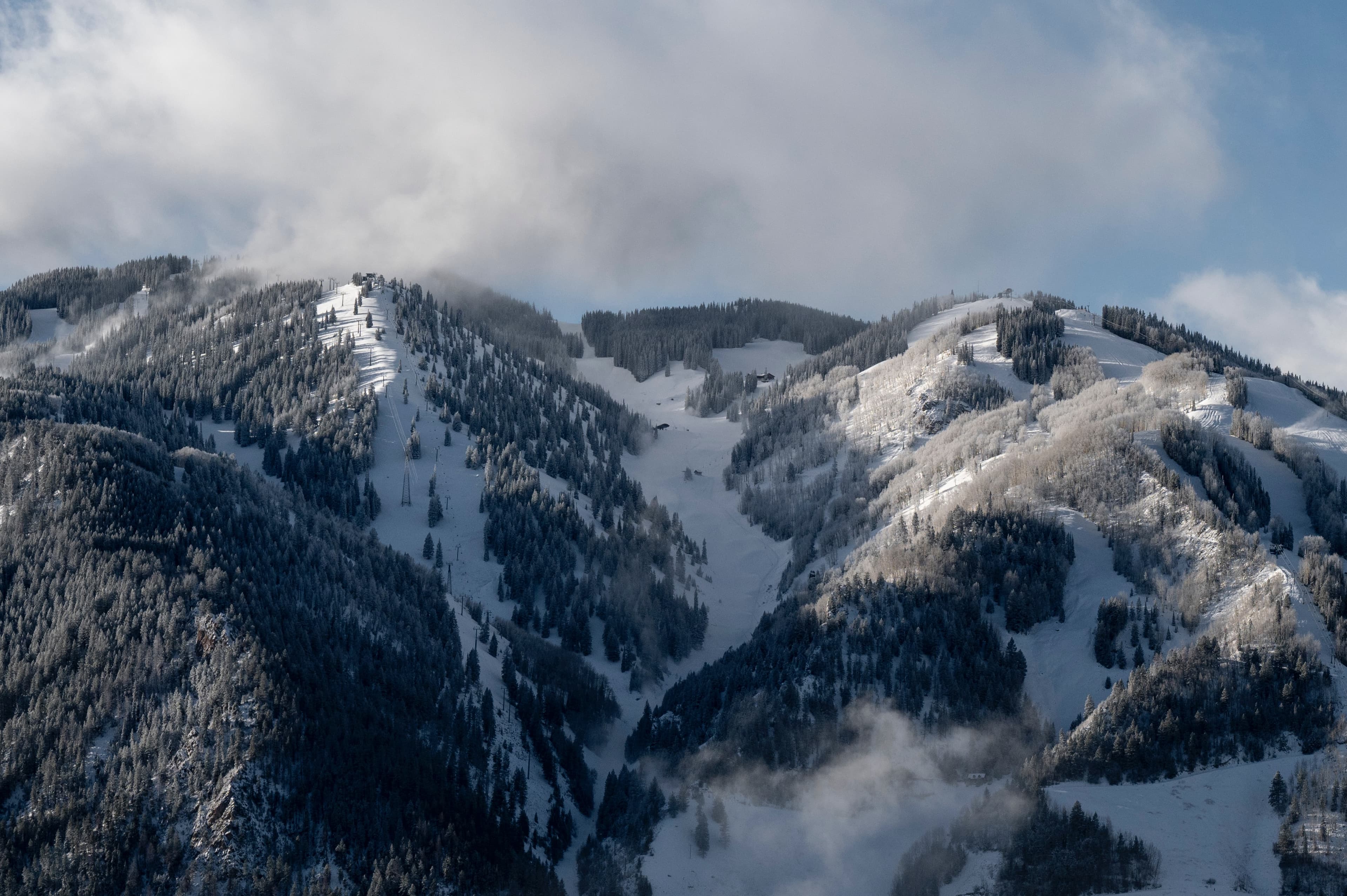 snow-covered mountain with ski trails during daytime