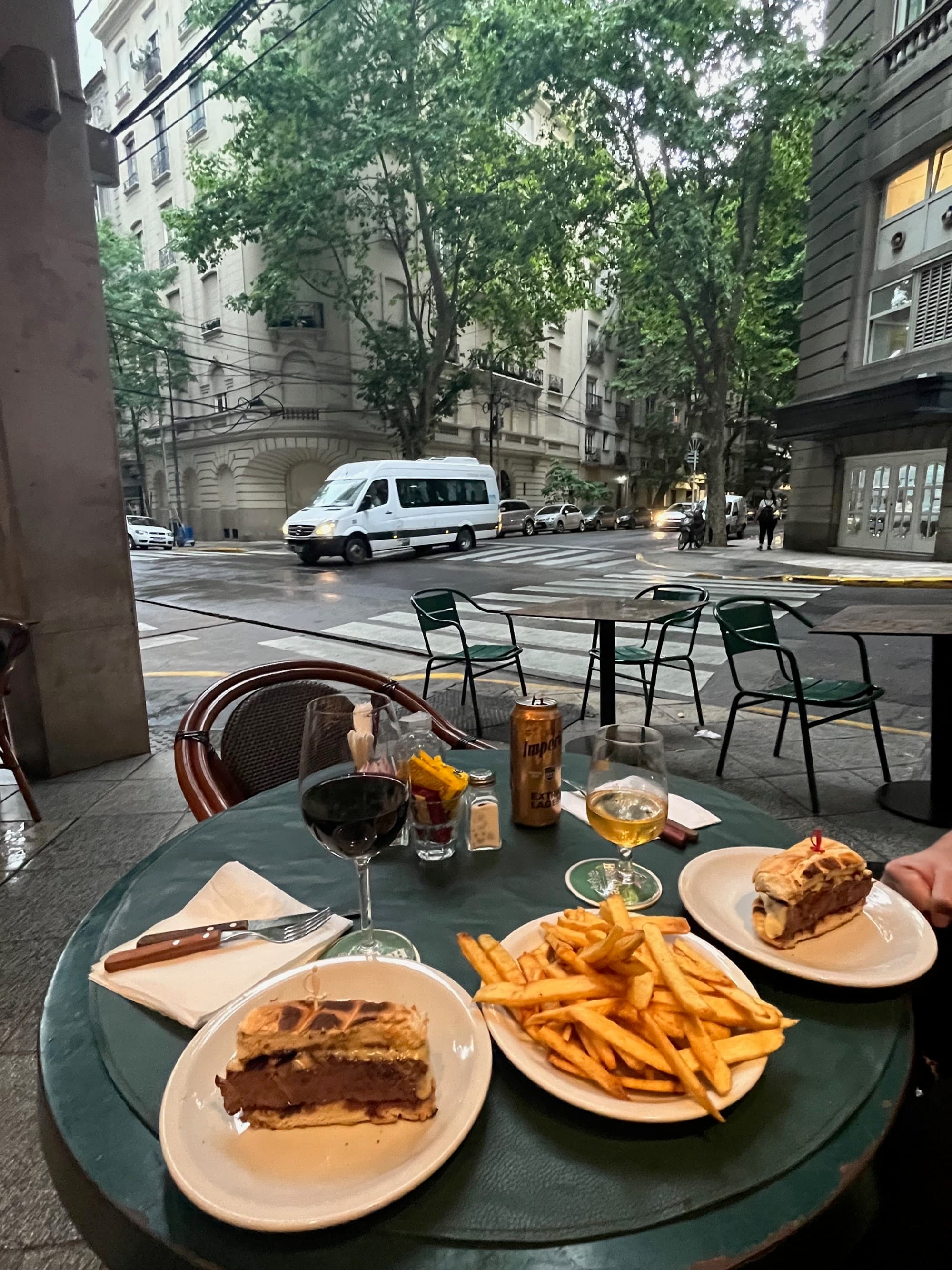 Fries and cake slices on a table at outdoor sitting of a restaurant.