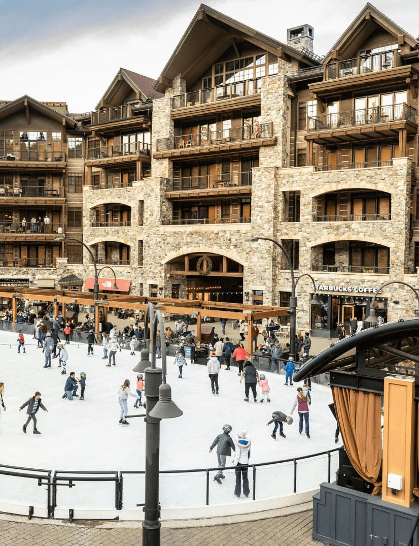 A view of a ski gondola with the very blue Lake Tahoe faded in the distance.