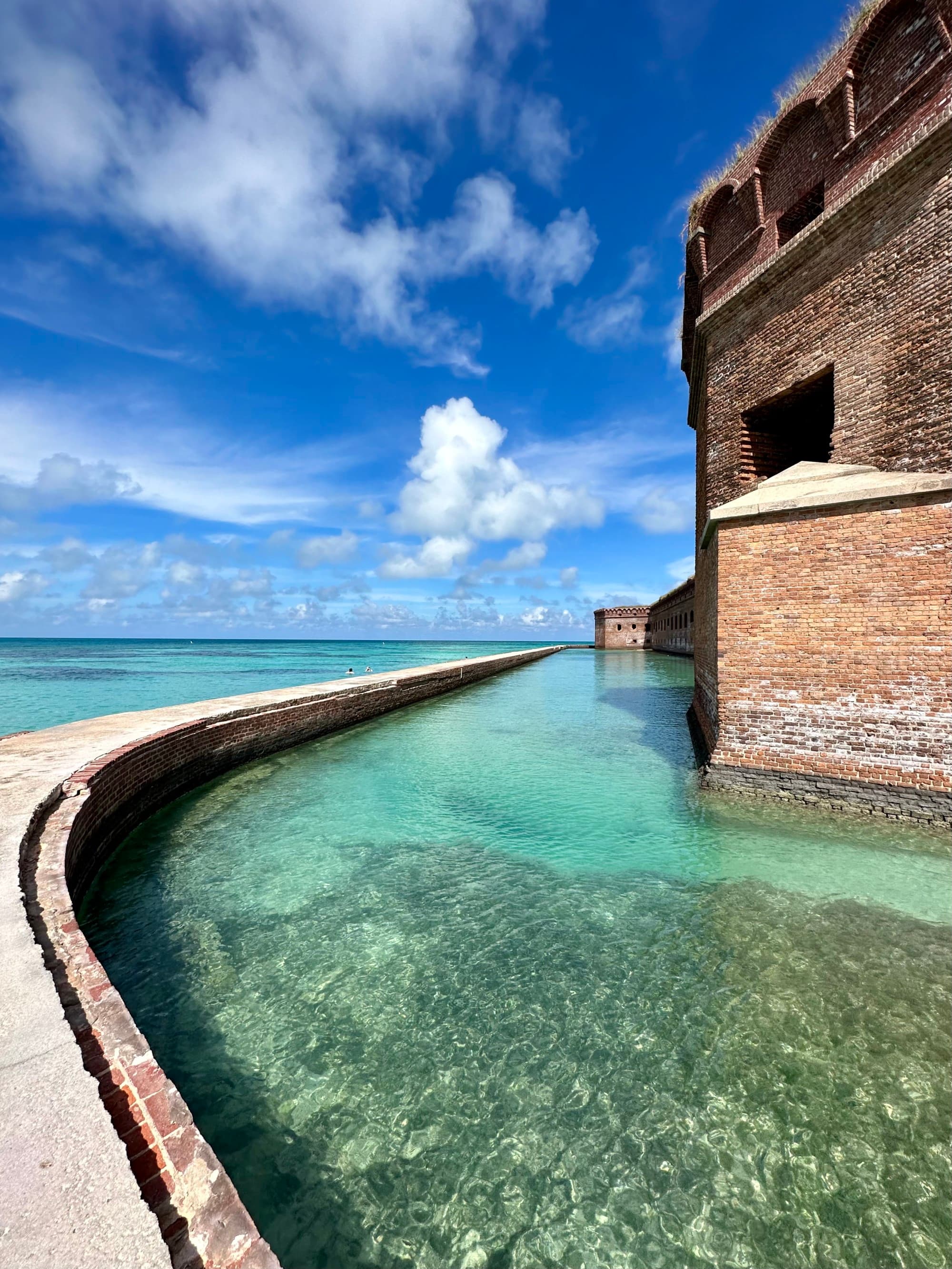 A picture of water near a brown concrete building taken during daytime.