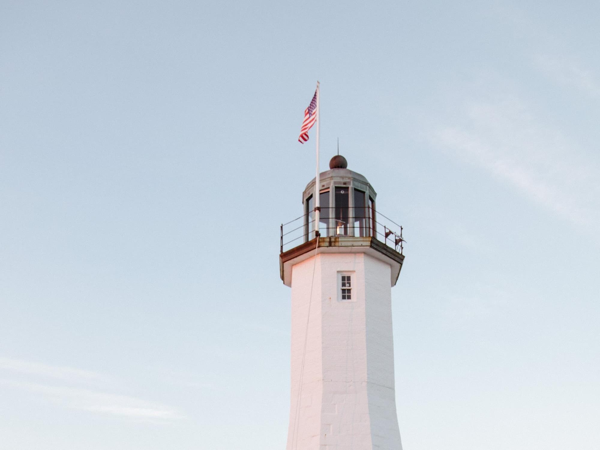 Massachusetts white lighthouse with American flag