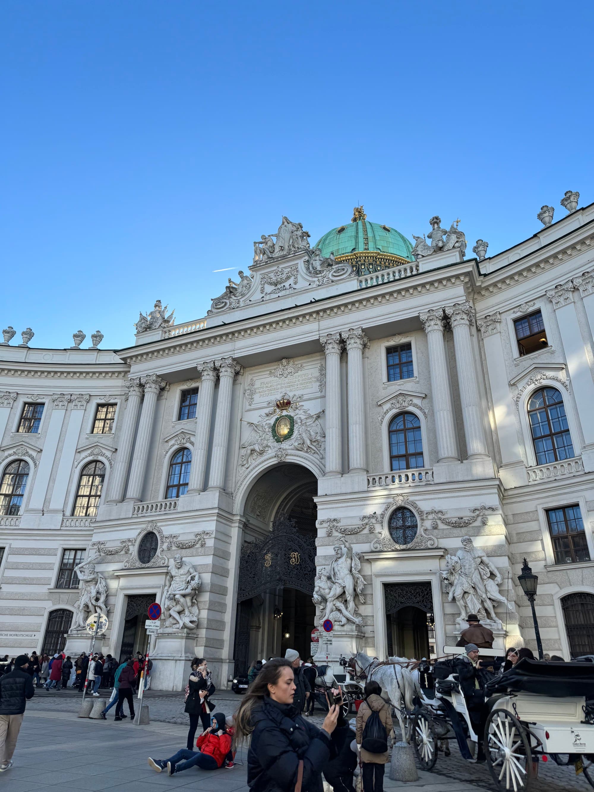 People in front of building with statues.