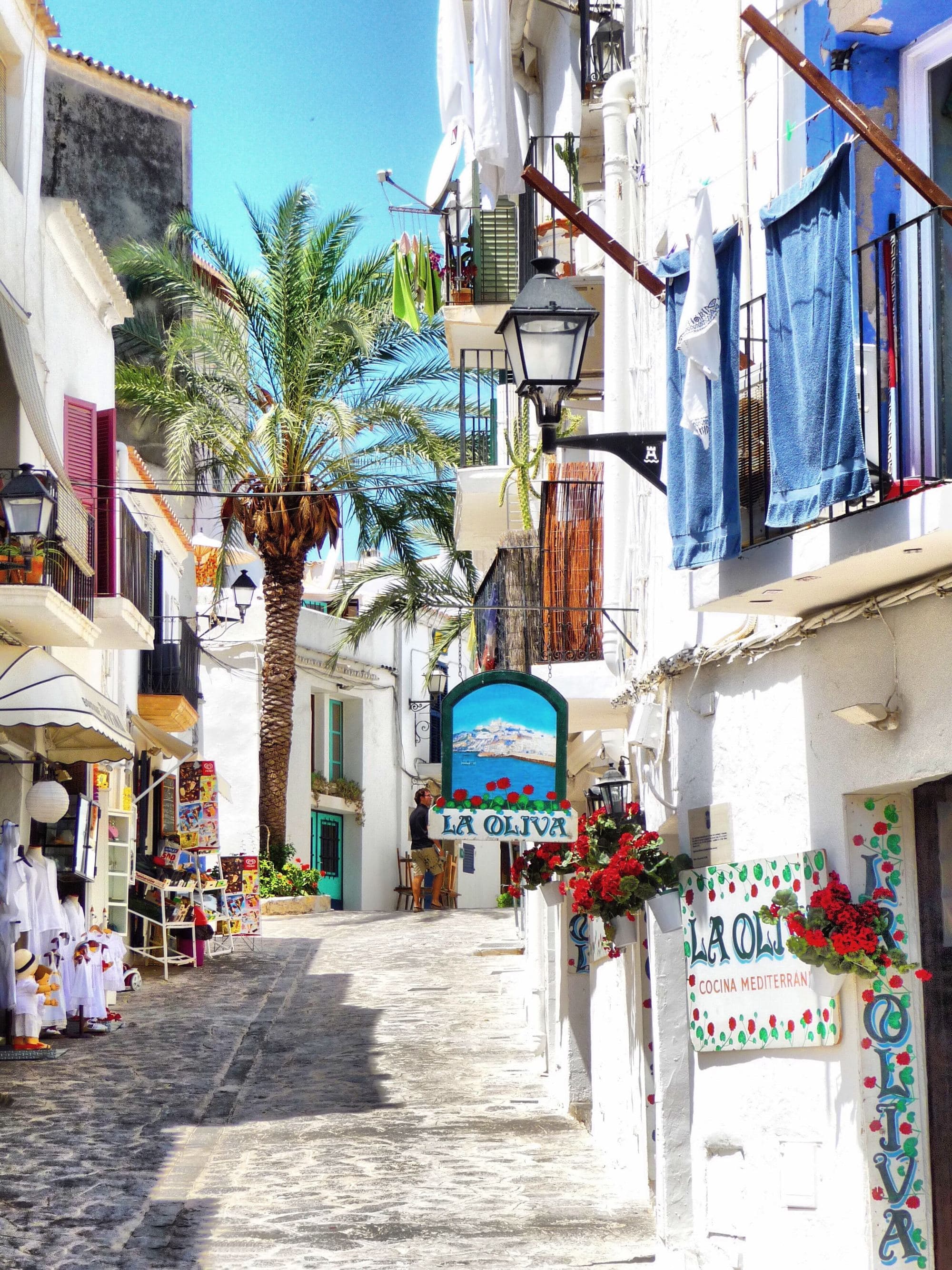 A street in town surrounded by white buildings.