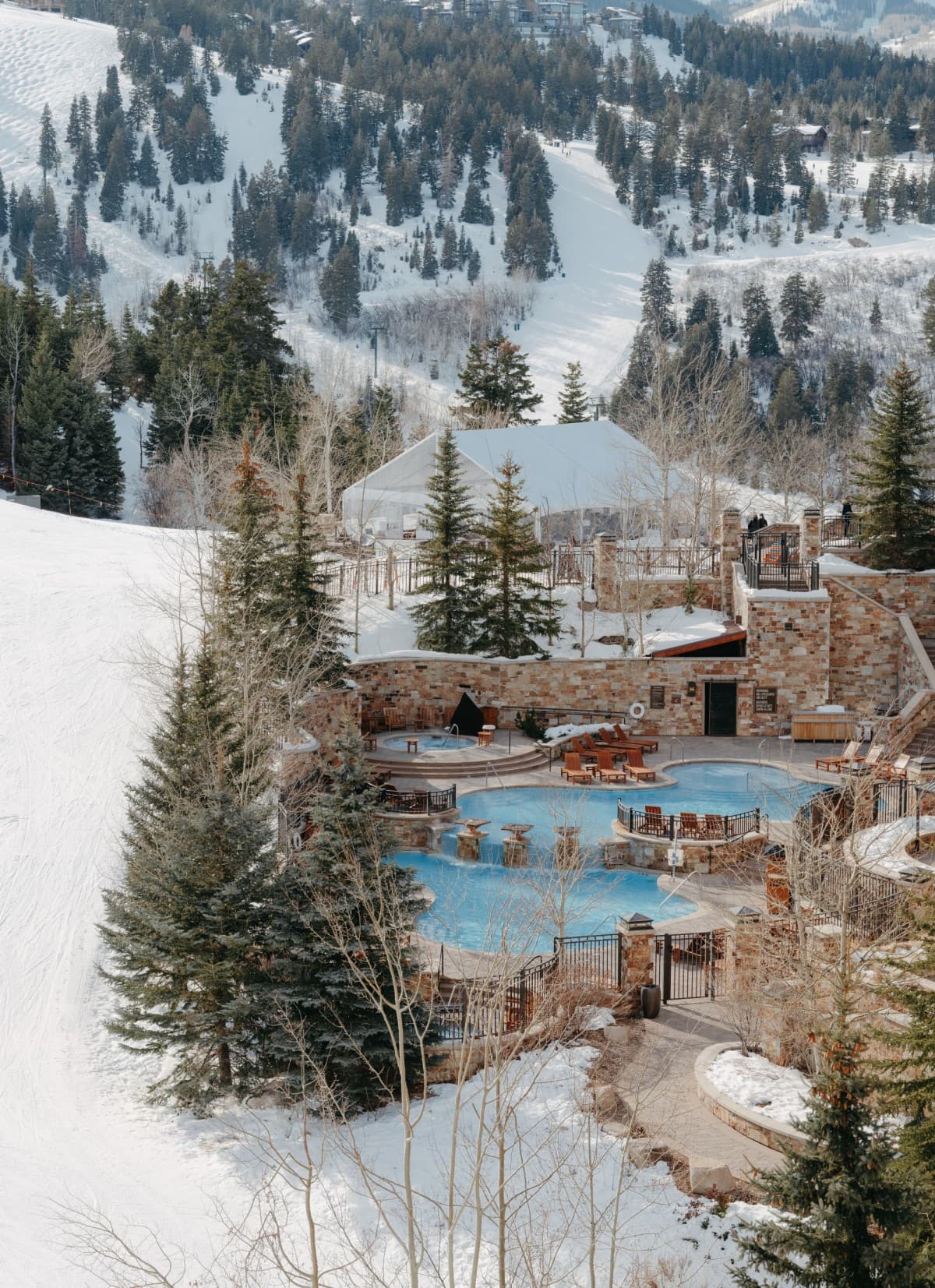 pool surrounded by snowy mountains during daytime