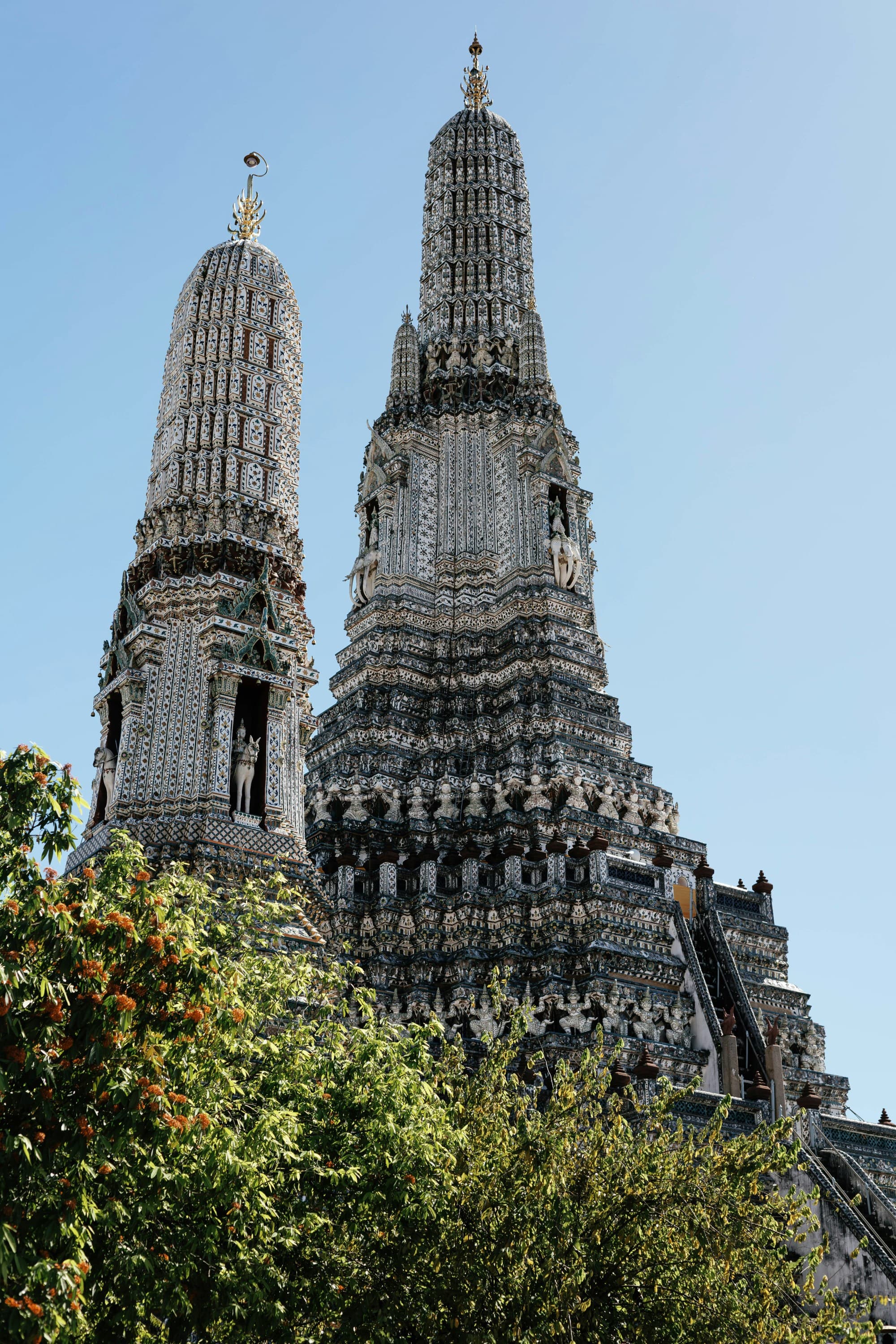 Two tall grey temple towers with a tree below