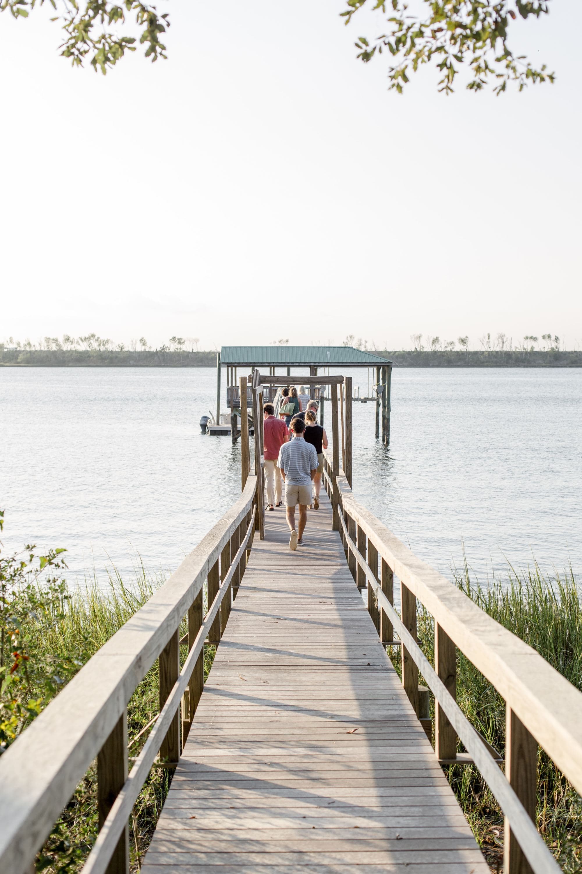 a long dock into a calm bay of water