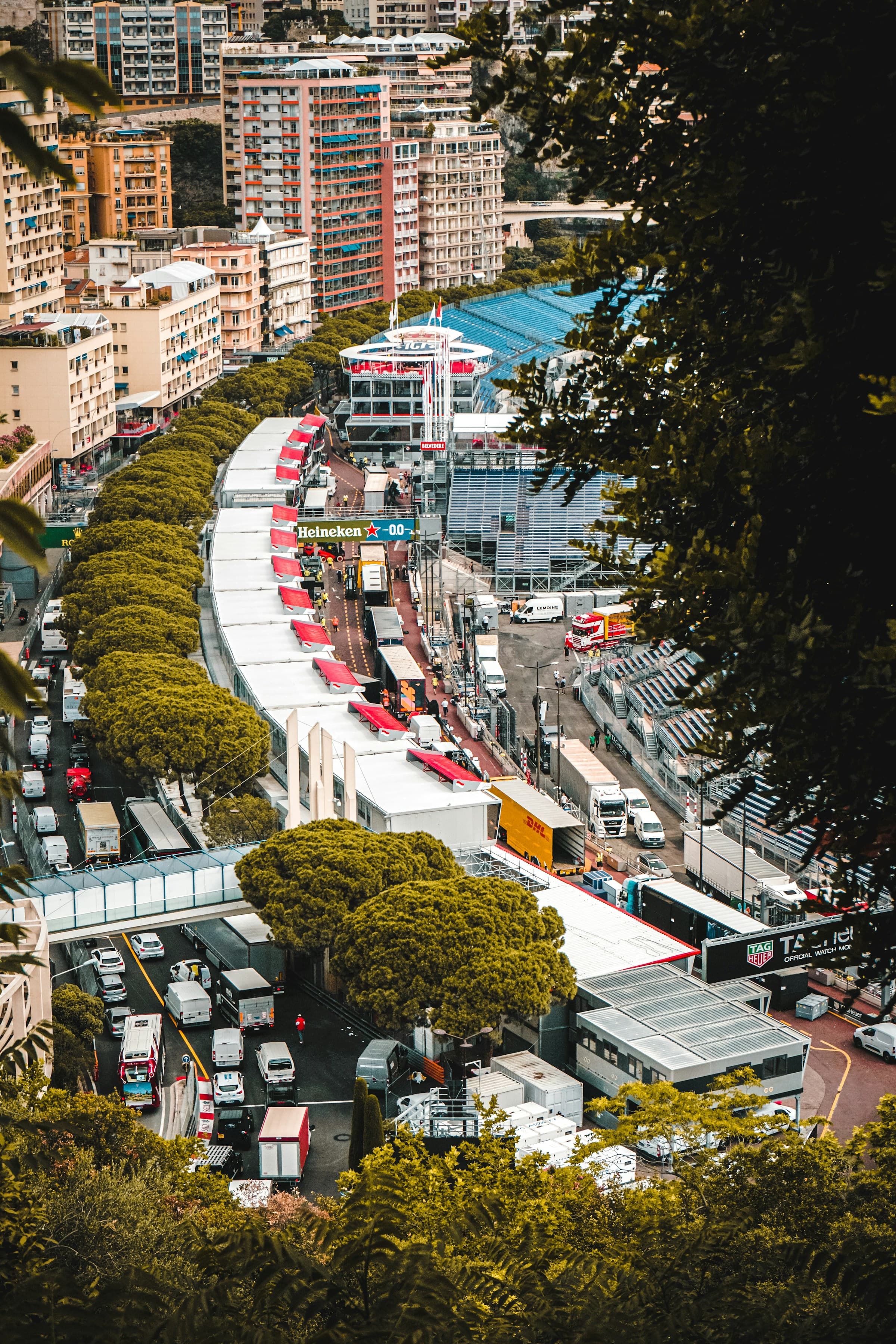 An aerial view of Monaco surrounded by bustling cars, buildings and tents preparing for the race.