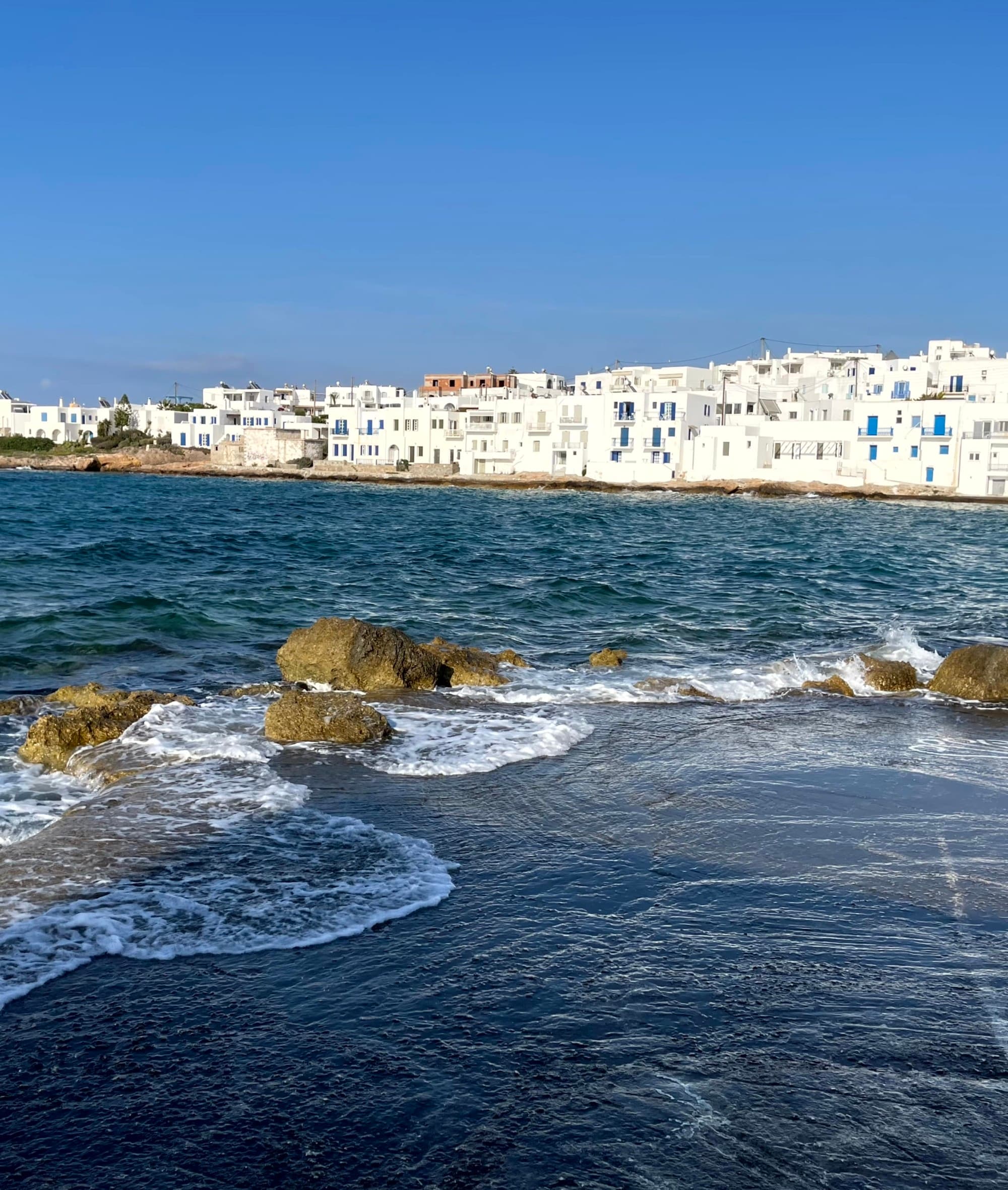 An aerial view of the sea surrounded by white colored houses.