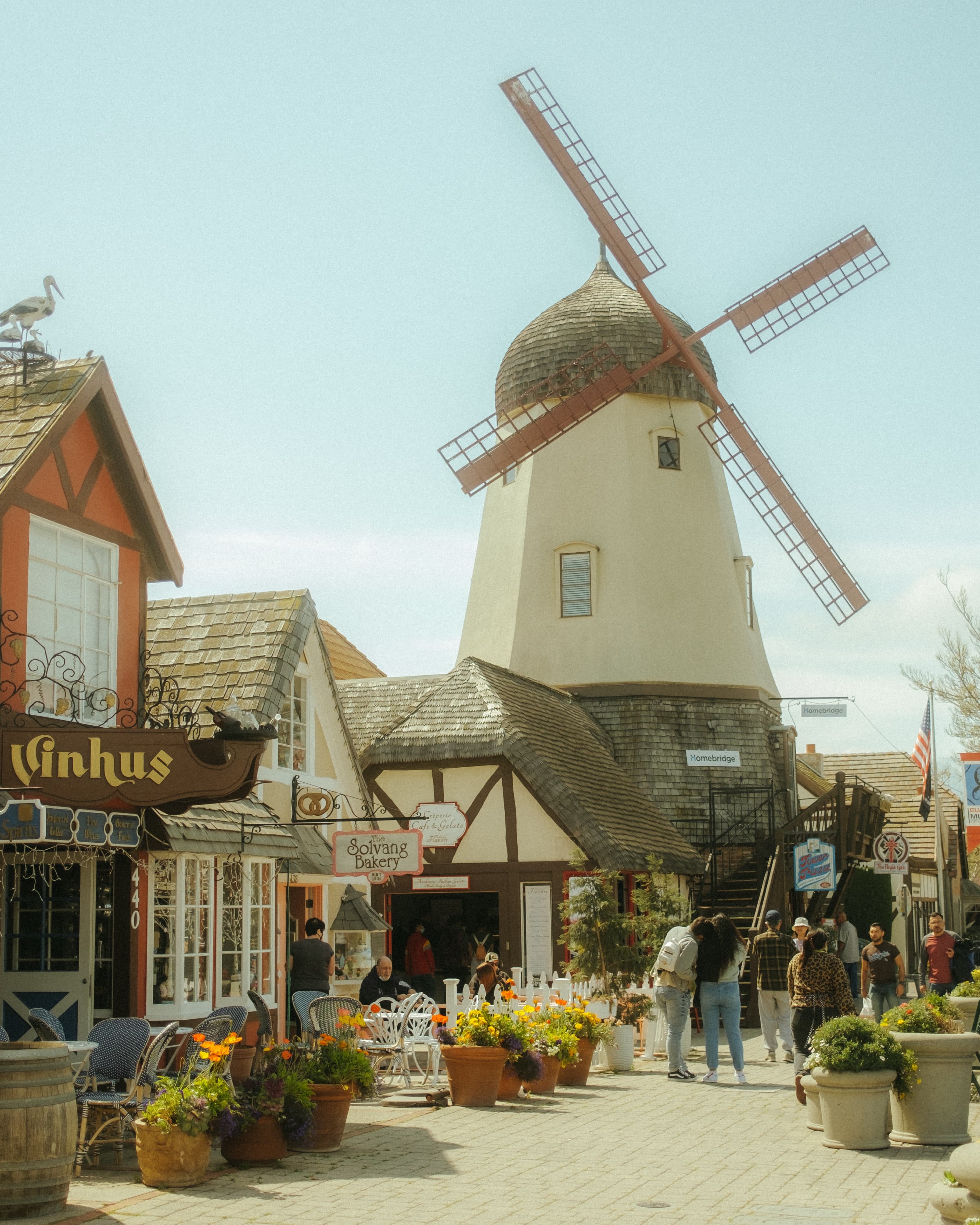 windmill and buildings with people walking during daytime