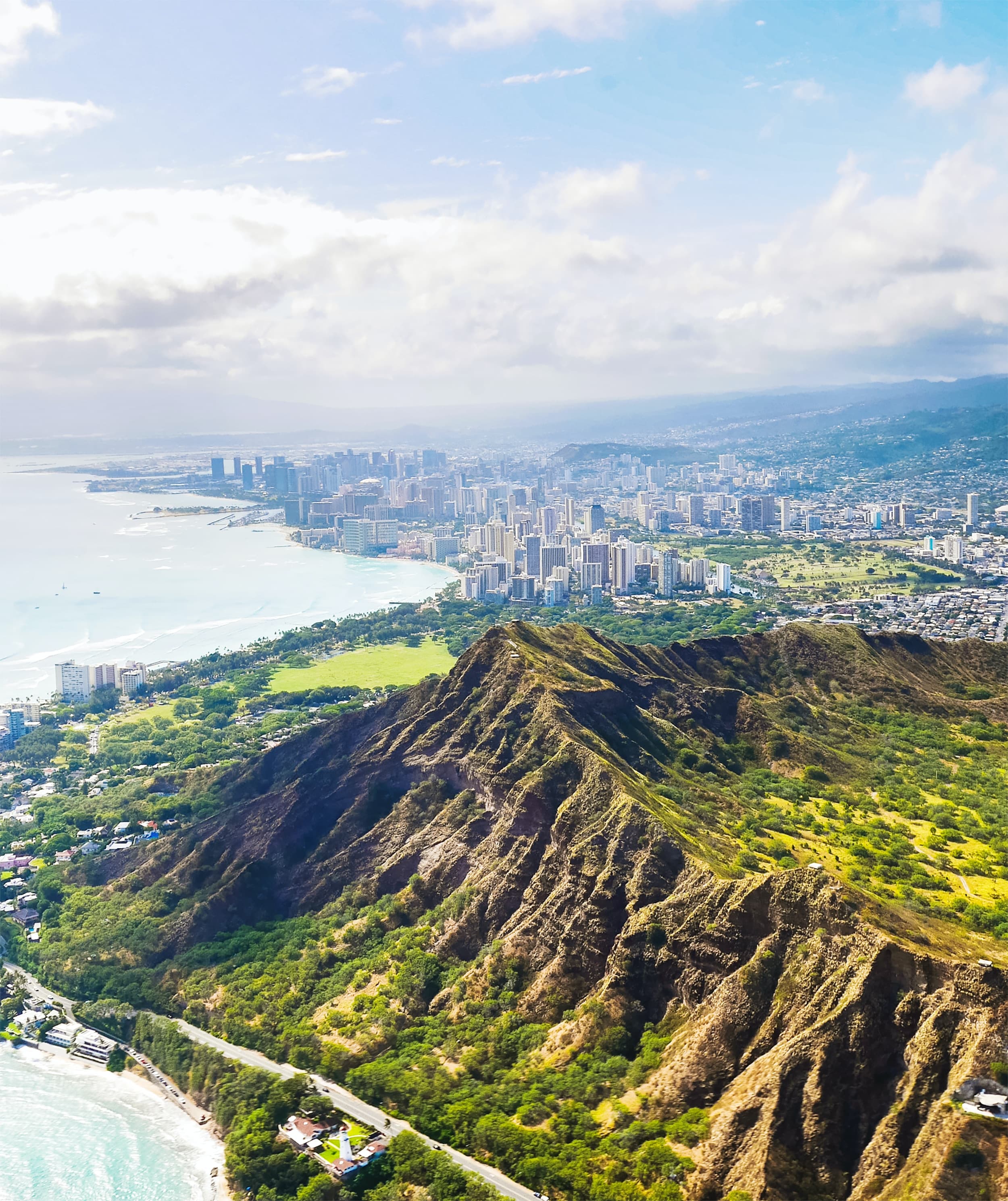 aerial view of mountains next to body of water and city