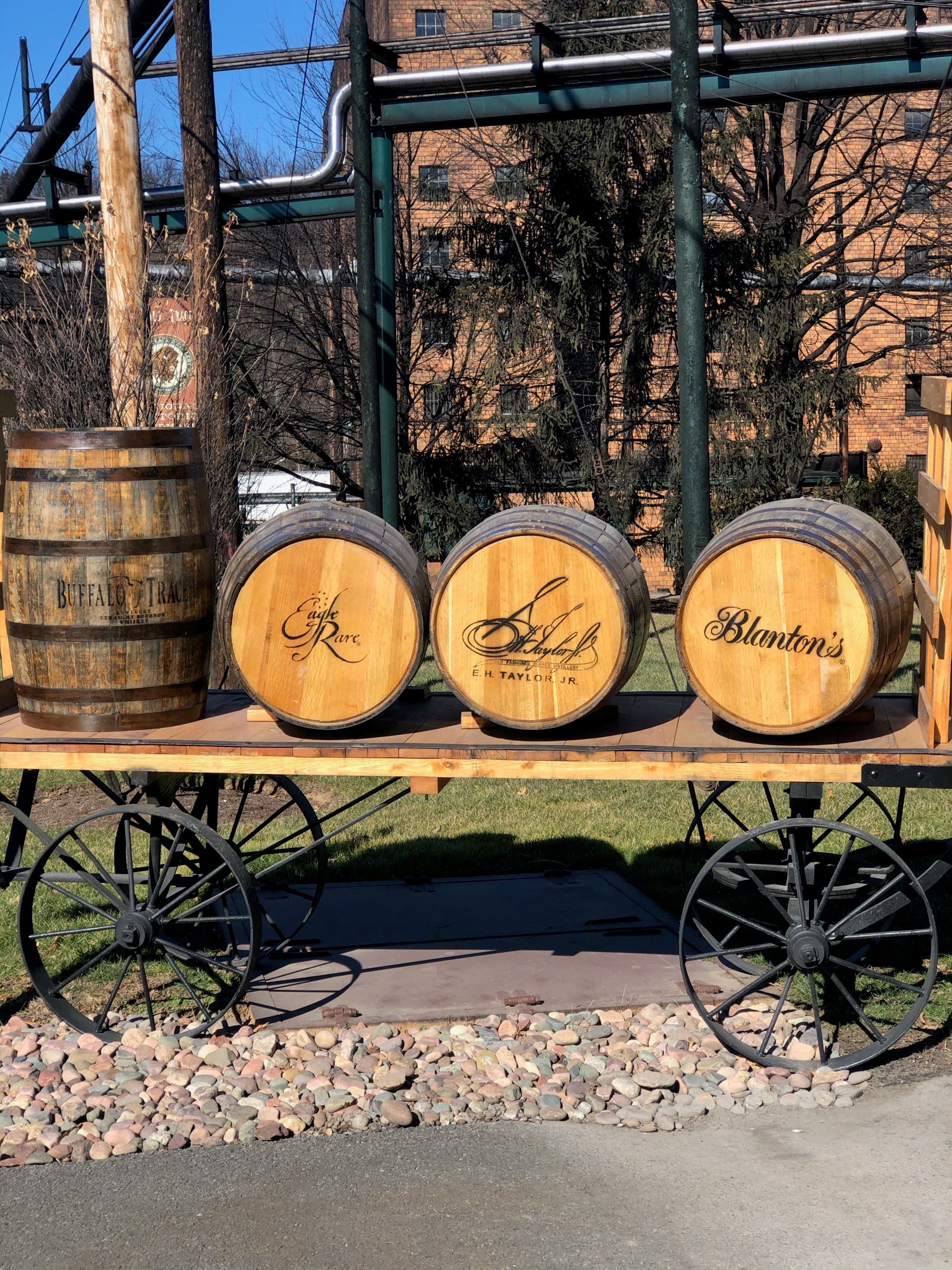 A wooden cart with barrels displayed outdoors under clear skies.