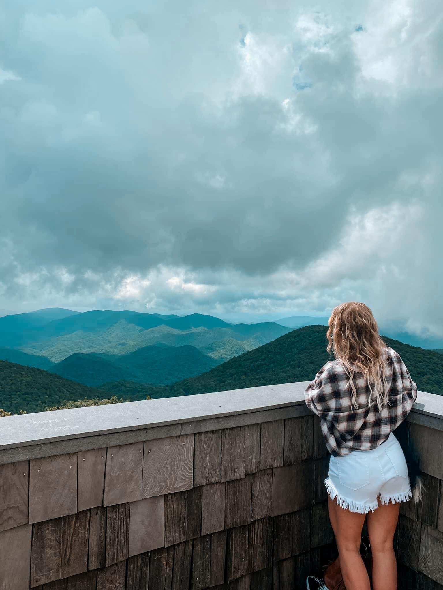 Advisor standing on a viewing platform over looking a mountain range and an overcast sky at Looking at Brasstown Bald.