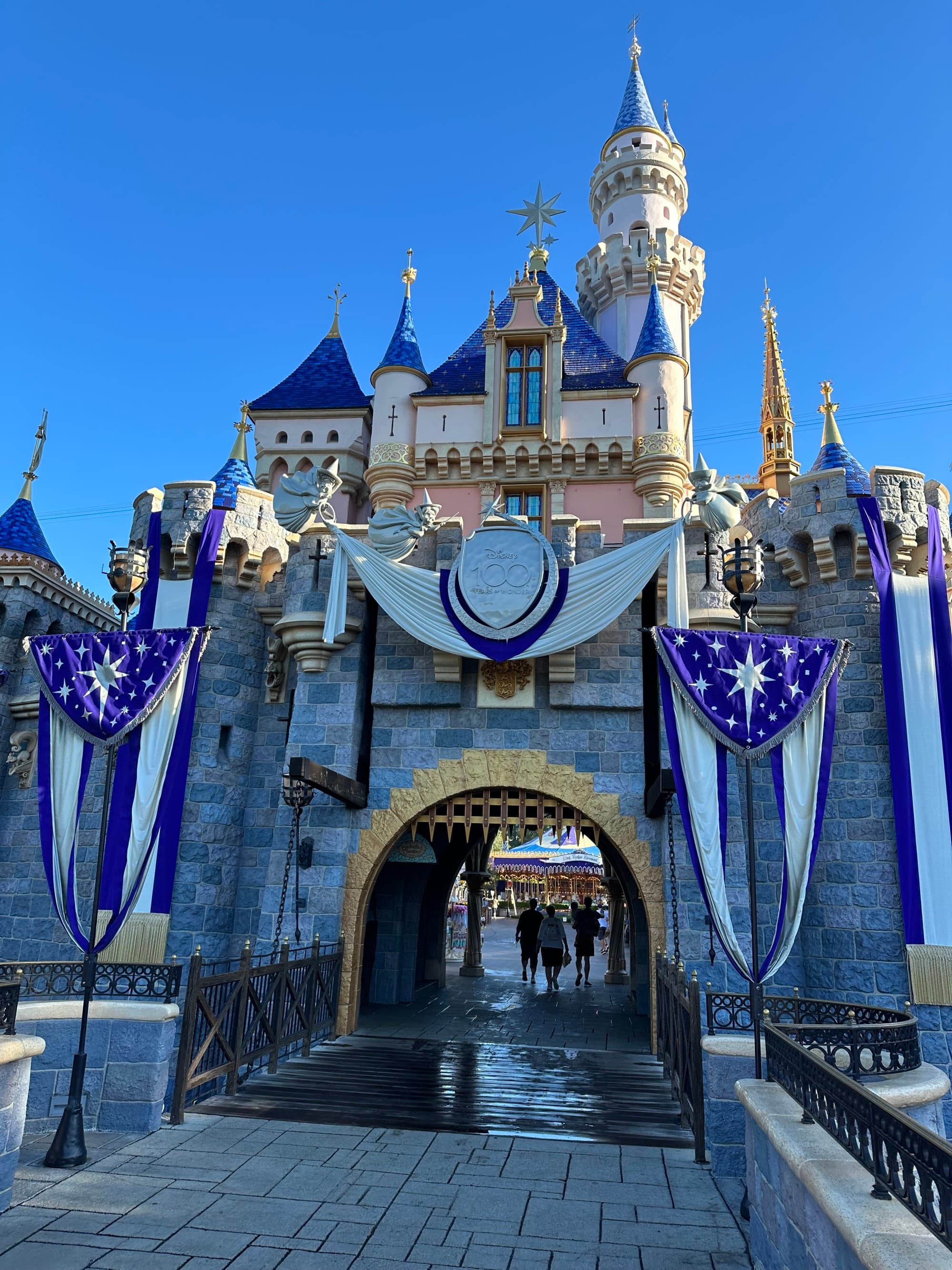 A castle with blue and gold turrets, adorned with star-spangled banners, under a clear blue sky.