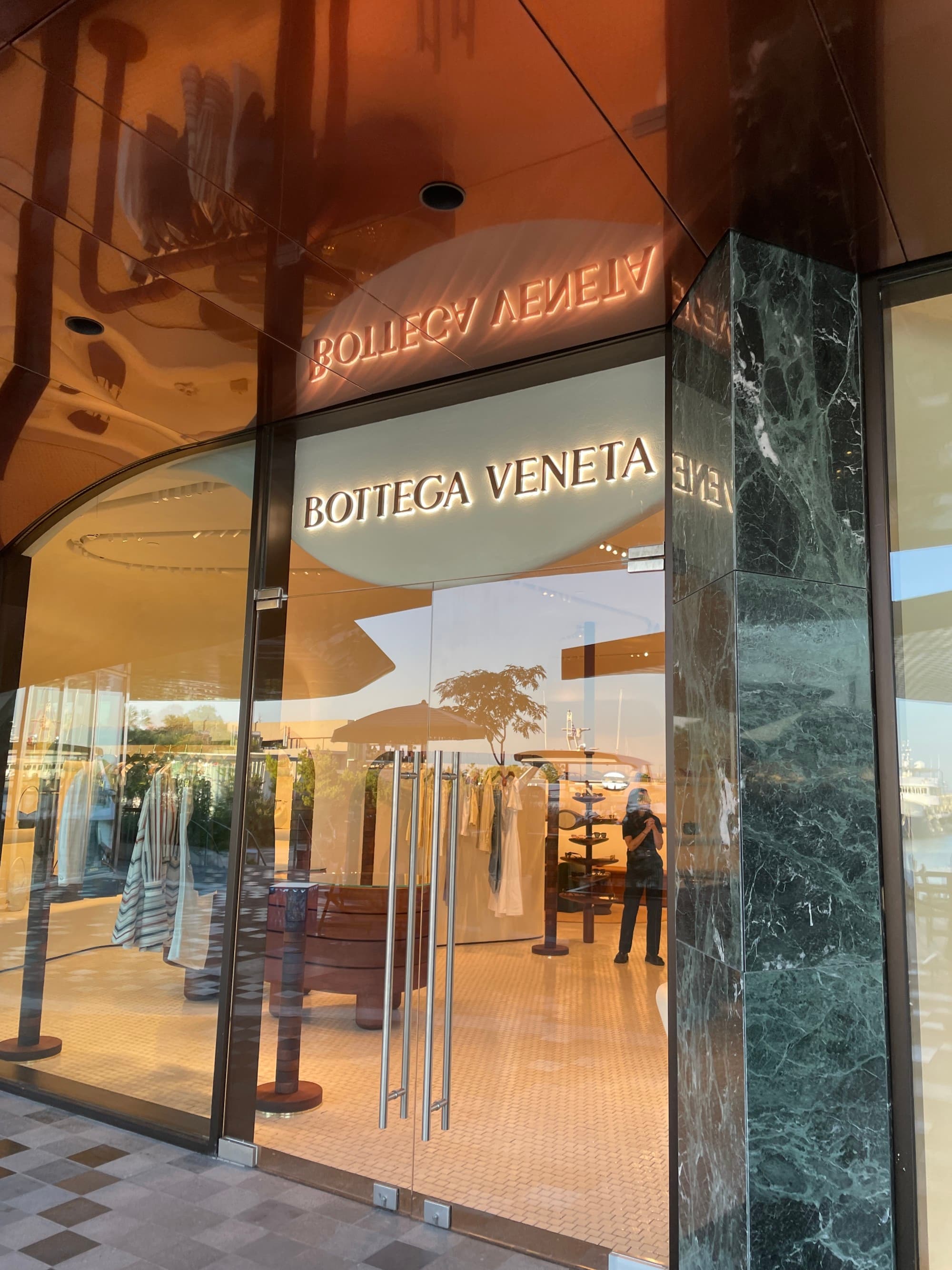 A view through the windows of the luxury brand Botega Venenta storefront.