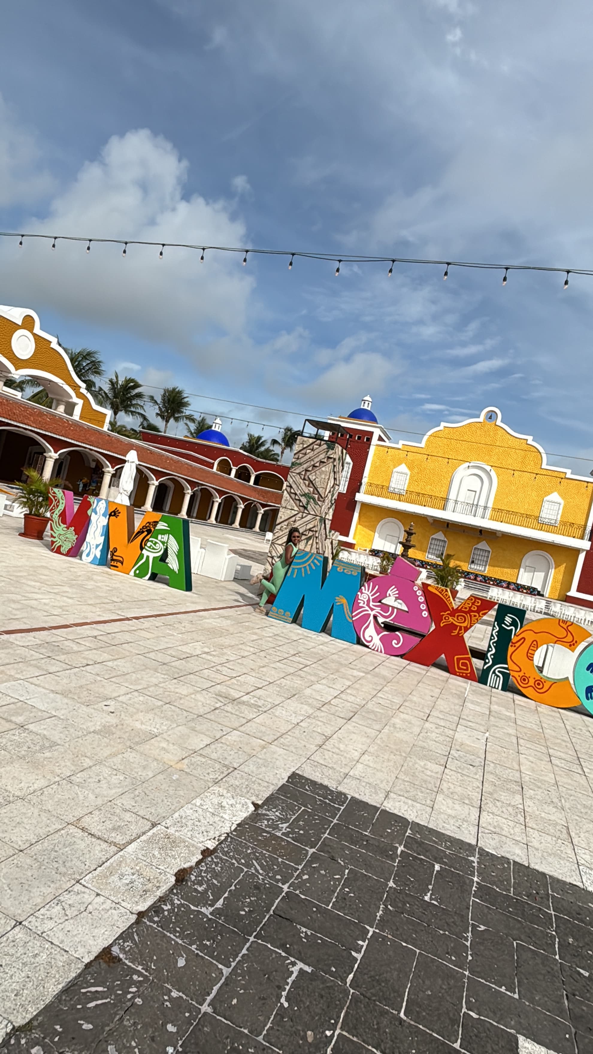 Bahia Principle Luxury Tulum is filled with brightly colored buildings on a cloudy day.