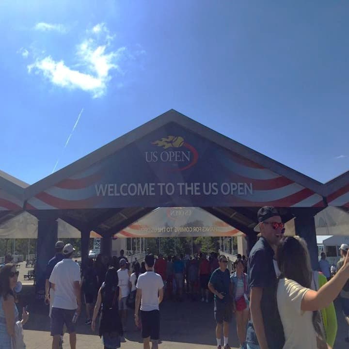 The image captures the excitement of people entering the US Open, highlighted by a prominent welcome sign.