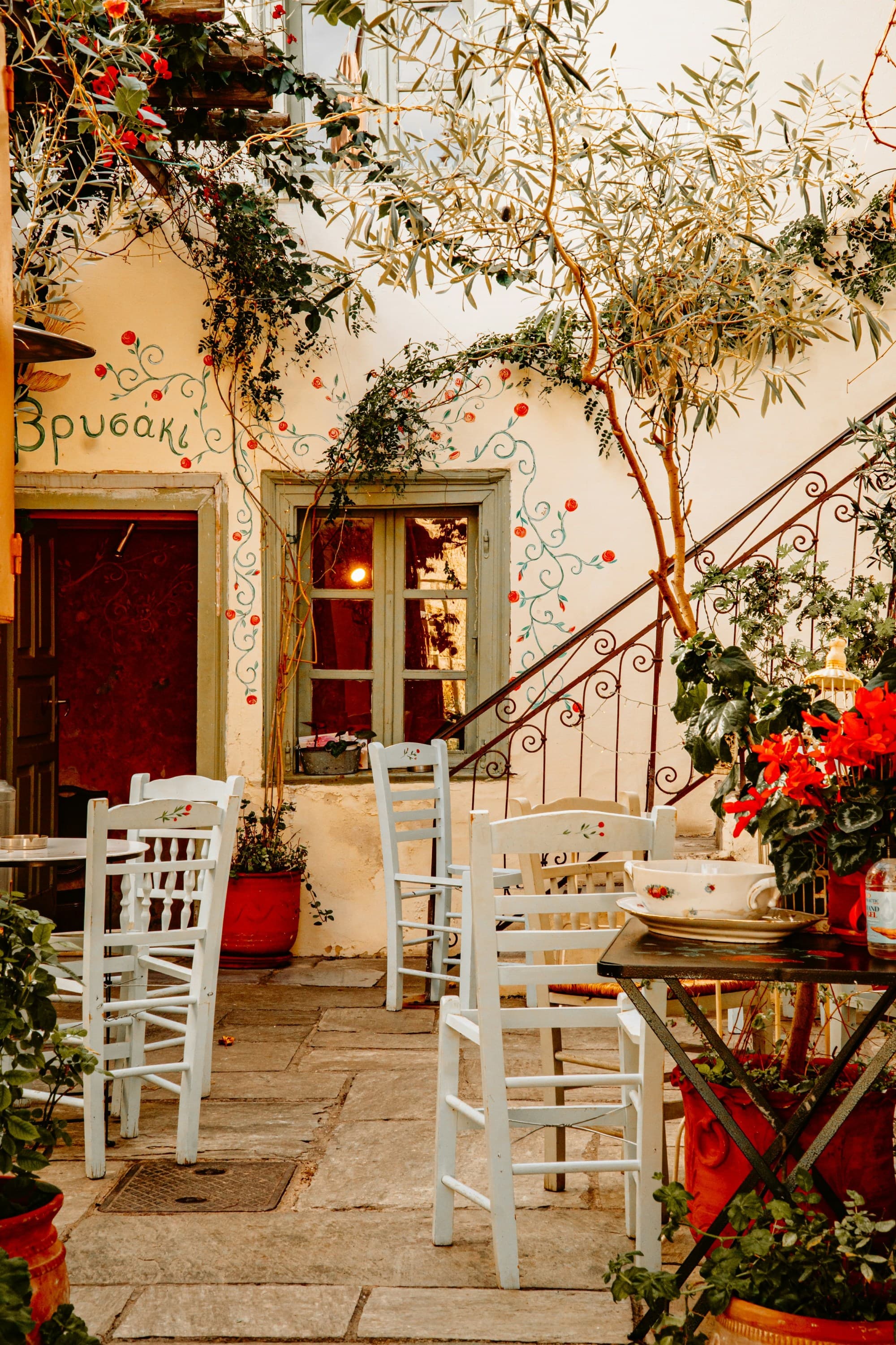 A patio with tables and chairs and potted plants