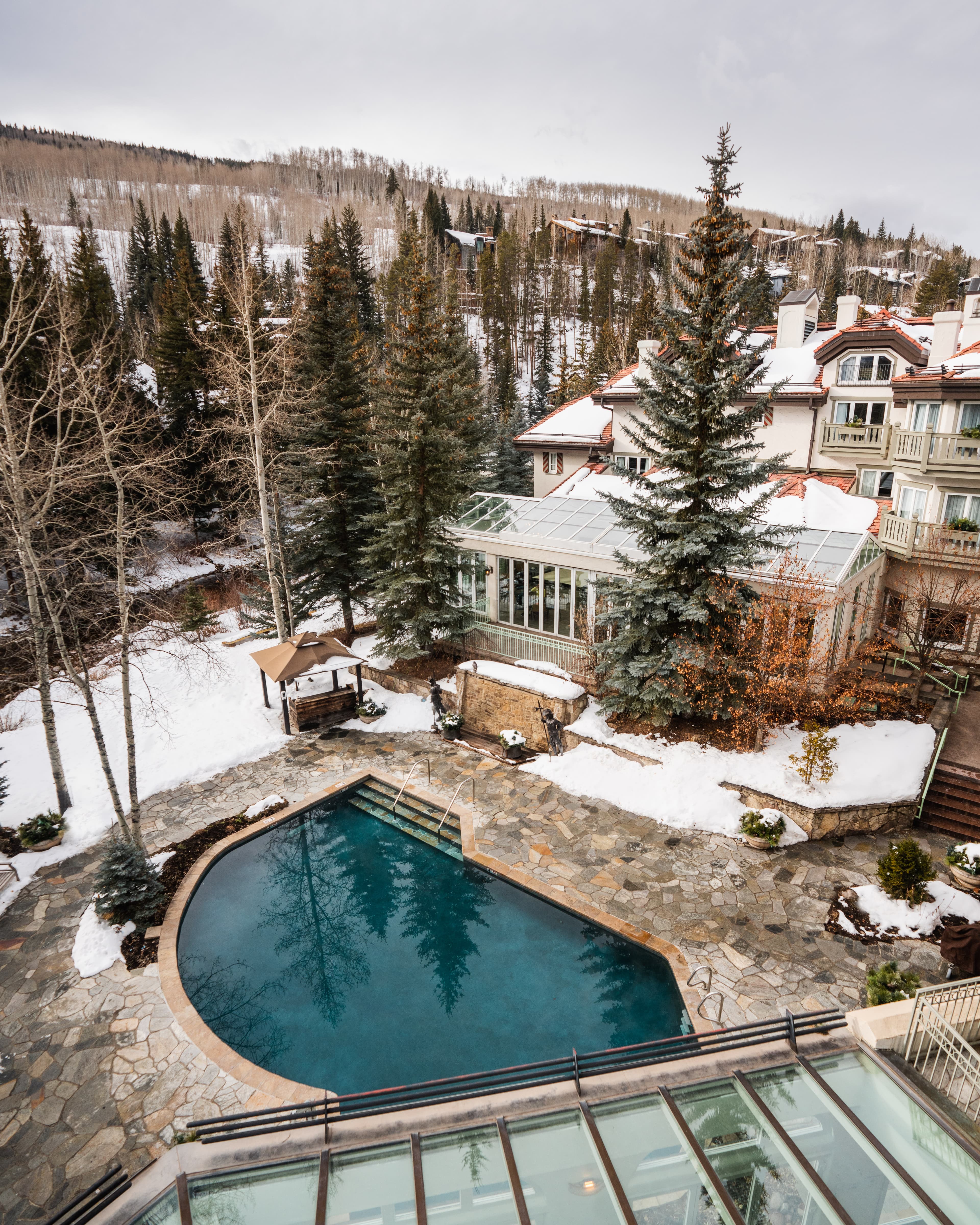 pool next to trees and white building with cloudy skies