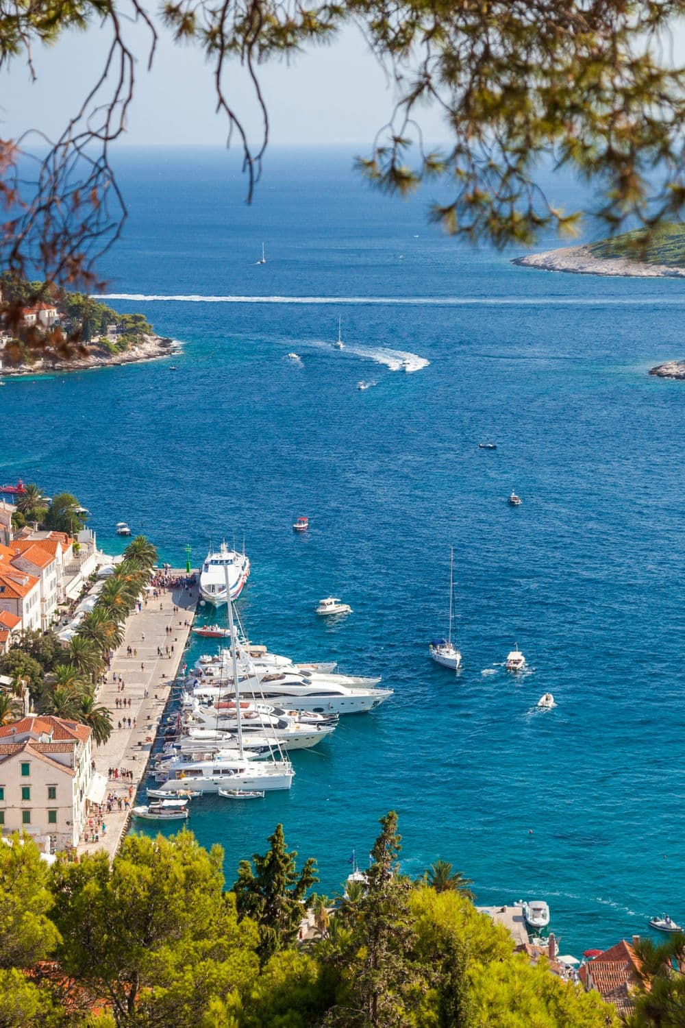 An ocean view from high up with boats and yachts in the distant waters.