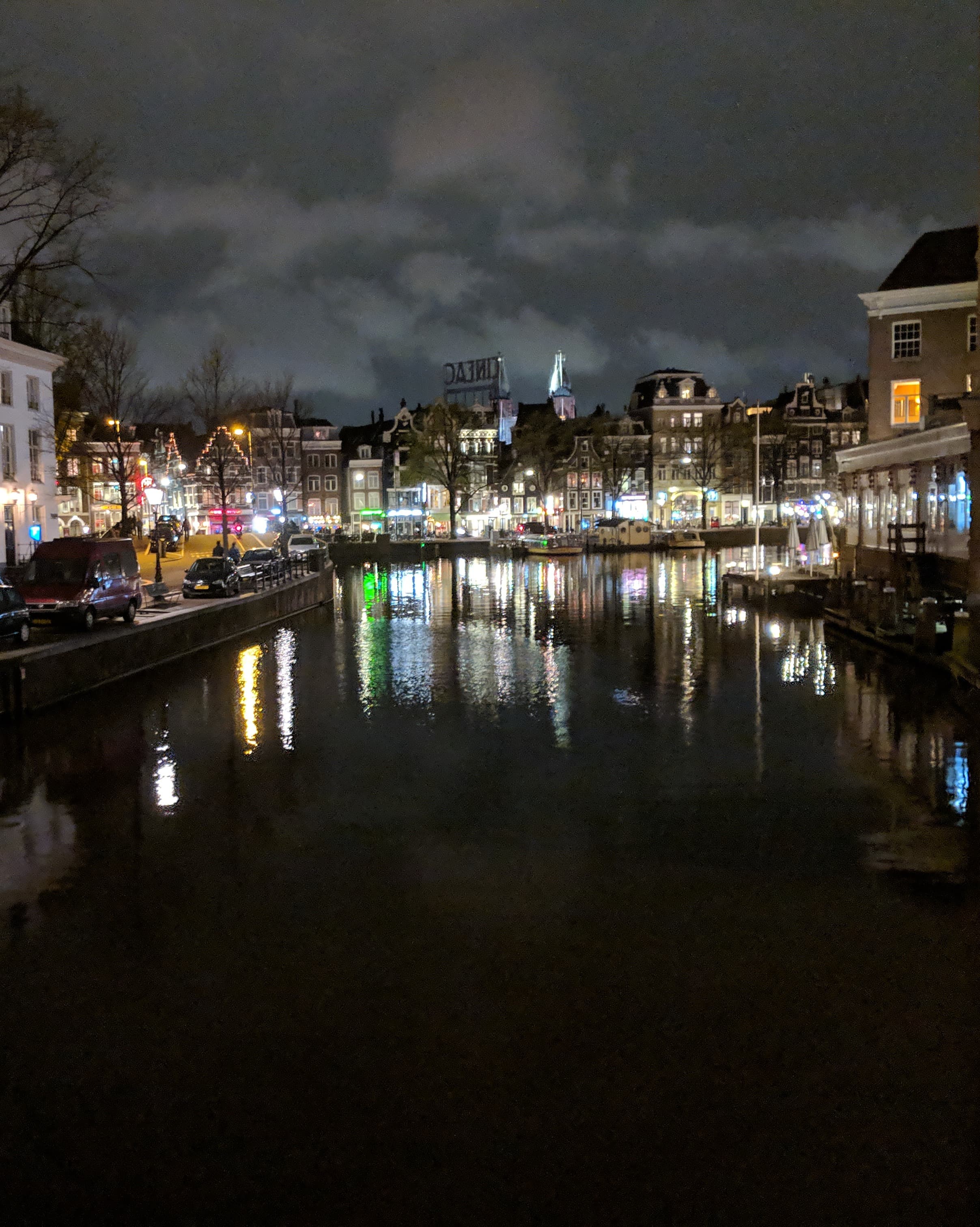 A lit-up Amsterdam on the river at night.