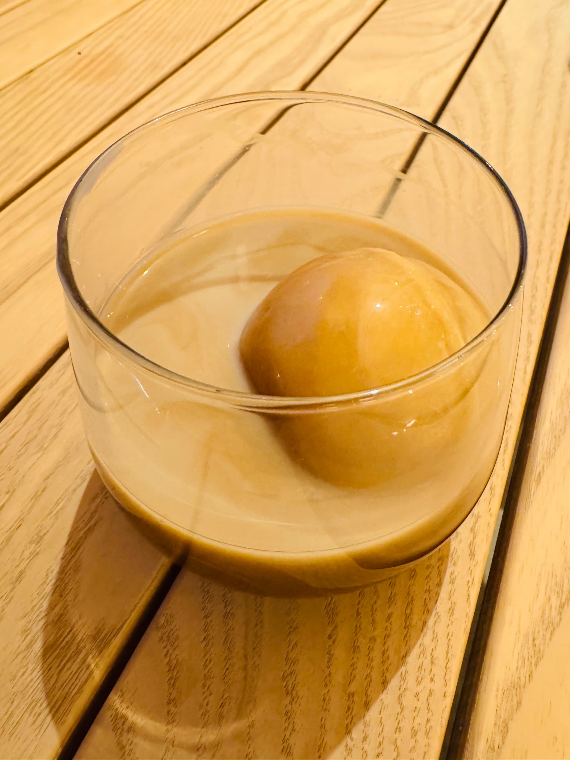 A drink sitting on a wooden table.